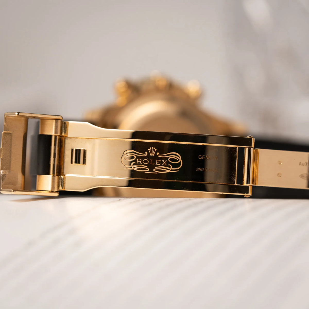 Klassisches Rolex Logo im Inneren der gelbgoldenen Oyster-Schliesse von der Rolex Daytona 126518LN mit Gelbgold-Gehäuse und schwarzem Zifferblatt am schwarzen Oysterflex-Armband aus Kautschuk