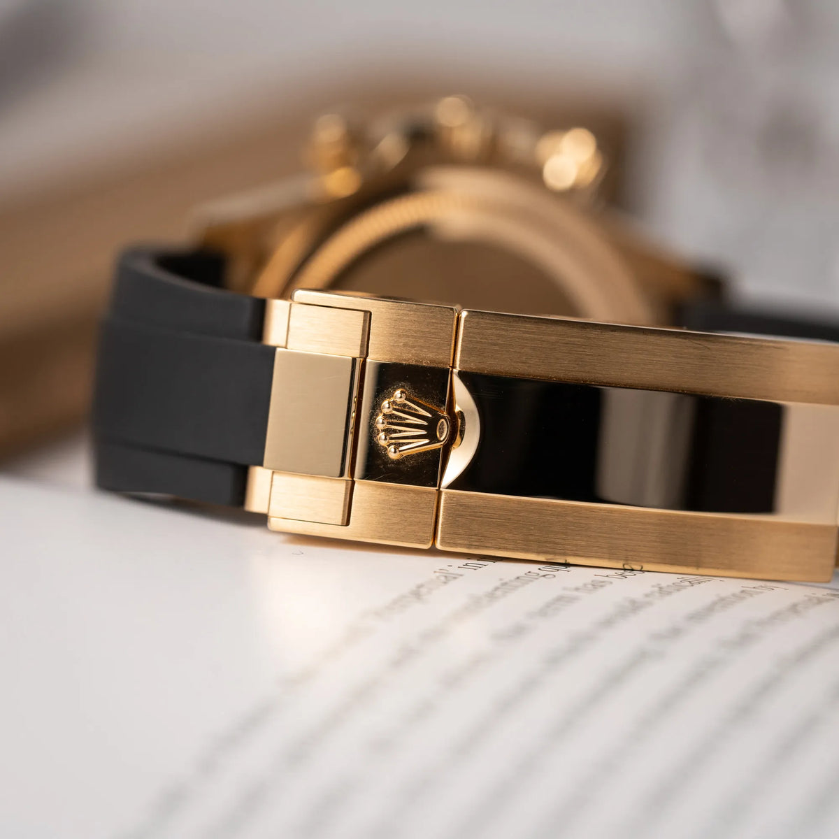Detailaufnahme der gelbgoldenen Oyster-Schliesse von der Rolex Daytona 126518LN mit Gelbgold-Gehäuse und schwarzem Zifferblatt am schwarzen Oysterflex-Armband aus Kautschuk