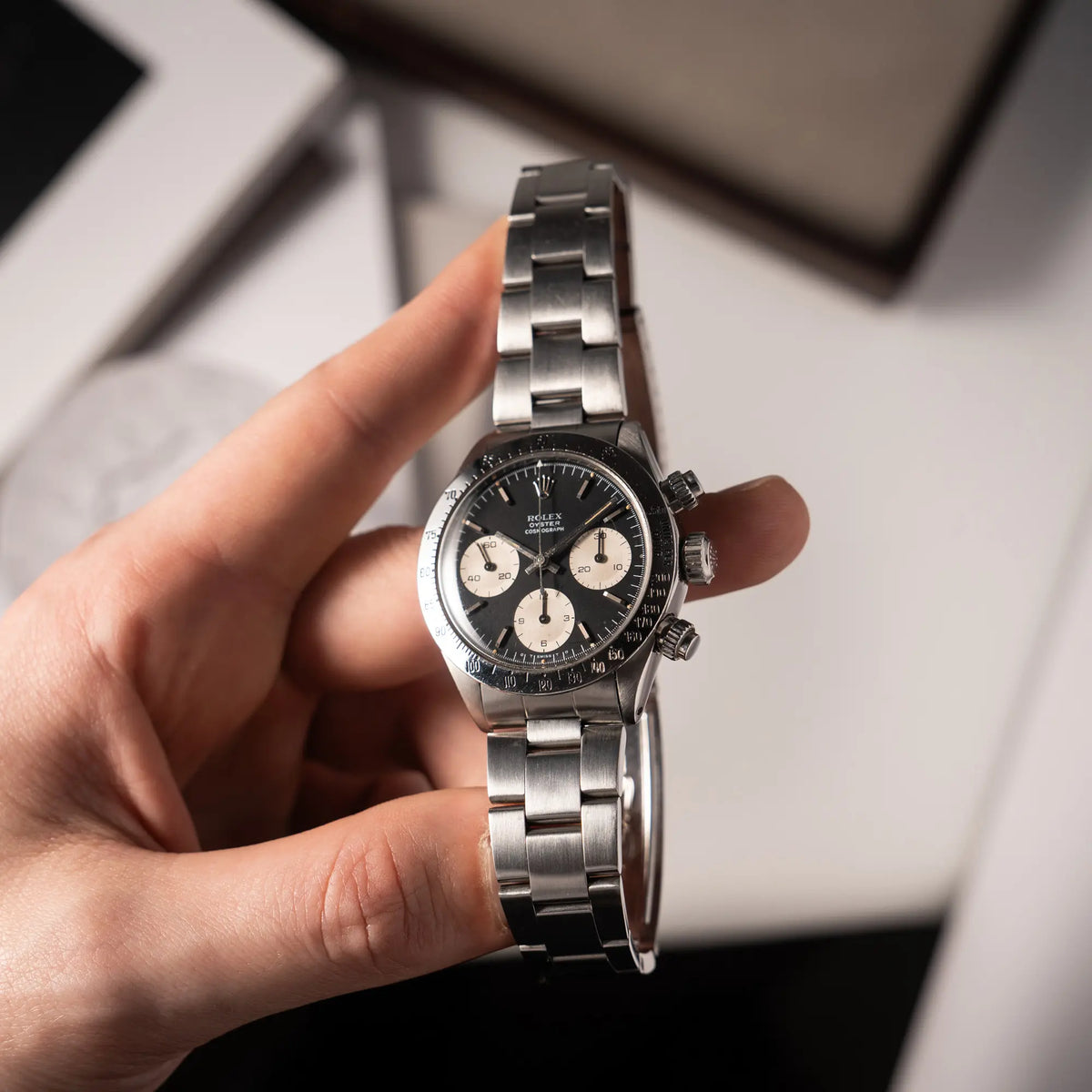 Mann hält die Rolex Daytona der Referenz 6265 mit Sigma-Dial in schwarz und weißen Sub-Dials im 37mm-Gehäuse aus den 70er Jahren in seiner Hand und präsentiert die uHr in die Kamera