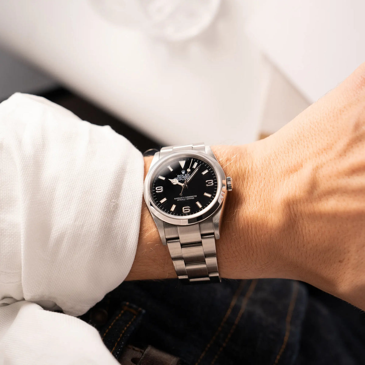 Mann trägt die Rolex Explorer 36 der Referenz 114270 mit dem klassischen schwarzen 3-6-9-Explorer-Zifferblatt am Oyster-Stahlband an seinem Handgelenk