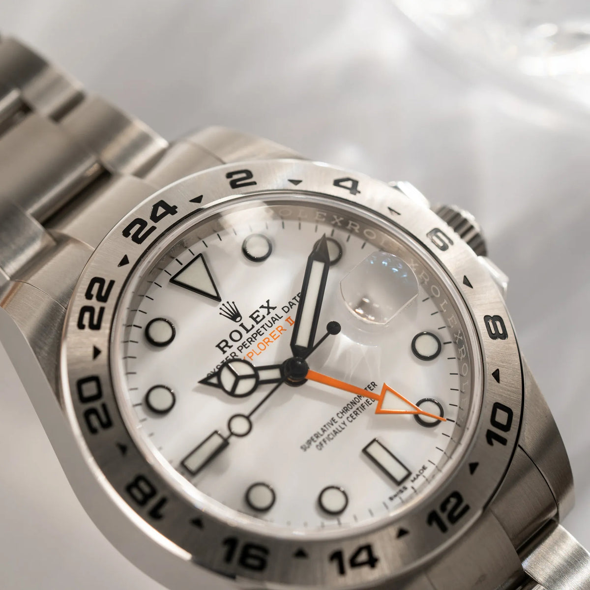 Detailaufnahme der Rolex Explorer II 216570 aus 2021 mit dem weißen Polar Zifferblatt mit dem typischen orangen GMT-Zeiger in einem sehr guten Zustand