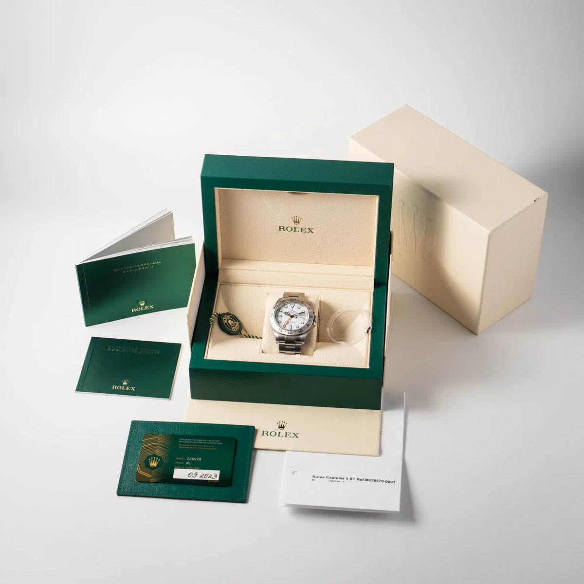 Lieferumfang zu der Rolex Explorer II der Referenz 226570 am Oyster-Stahlband mit dem weißen Polar-Zifferblatt und dem typischen orangen 24-Stunden-Zeiger, bestehend aus Box mit Umkarton, allen Booklets, Hangtag, Lünetten-Schutz, originaler Garantiekarte und Erstkaufbeleg