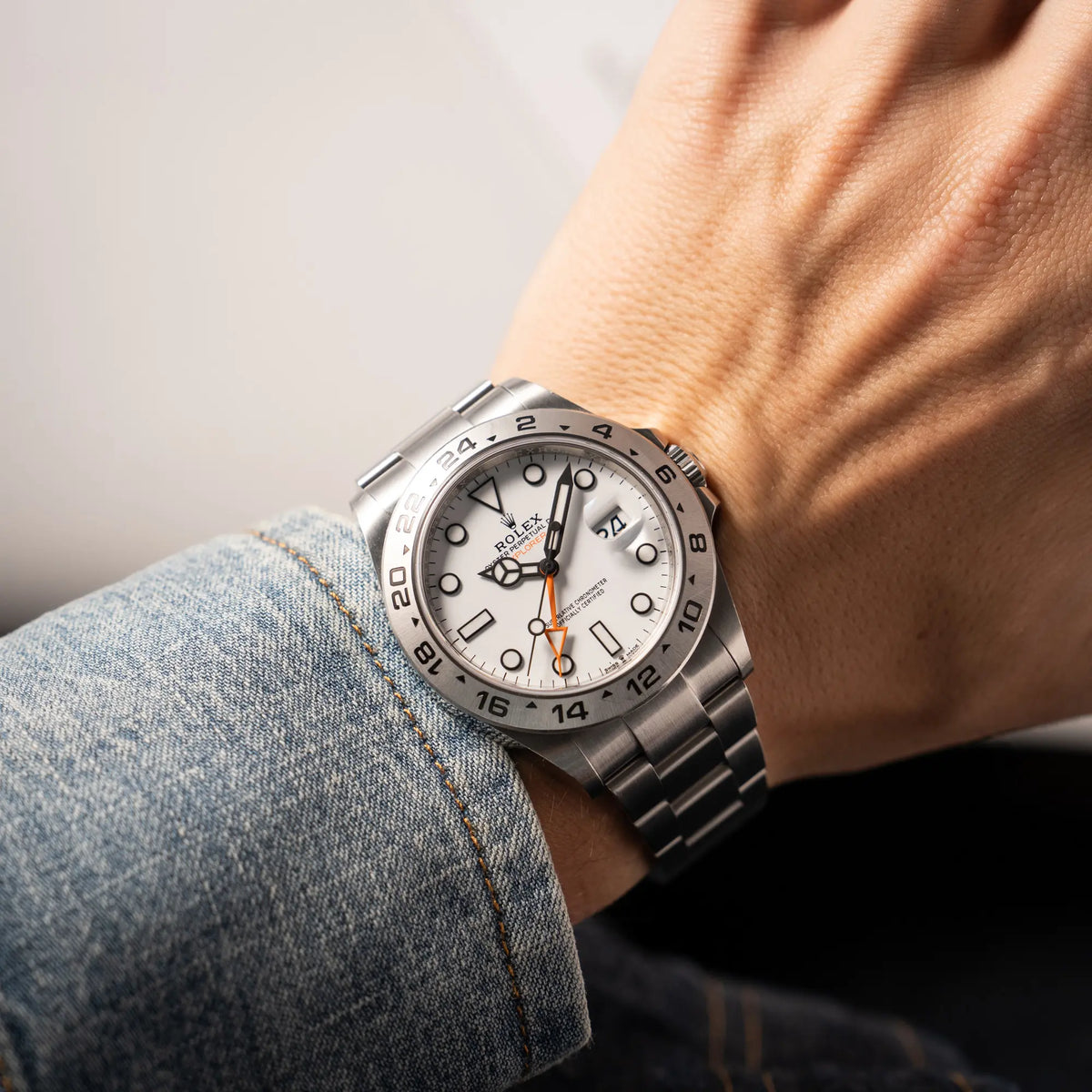 Wristshot mit der Rolex Explorer II der Referenz 226570 am Oyster-Stahlband mit dem weißen Polar-Zifferblatt und dem typischen orangen 24-Stunden-Zeiger an einem Männerhandgelenk