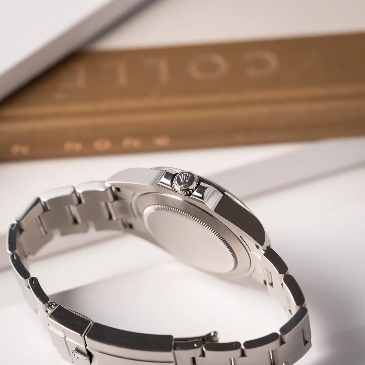 Produktfotografie der Rolex Explorer II der Referenz 226570 am Oyster-Stahlband mit dem weißen Polar-Zifferblatt und dem typischen orangen 24-Stunden-Zeiger zeigt die seitliche Gehäuseflanke mit Blick auf die Aufzugskrone