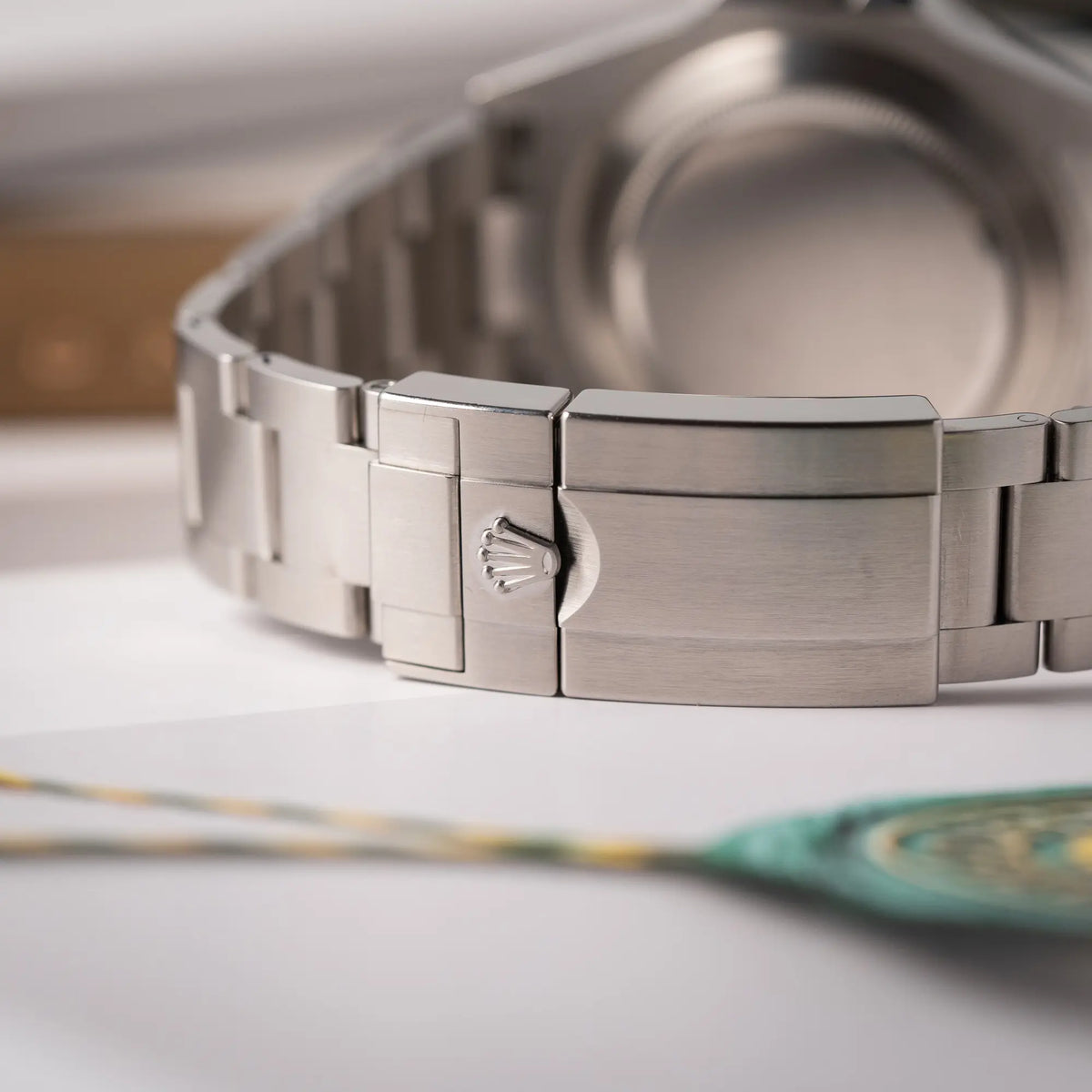 Detailaufnahme der Oyster-Stahl-Faltschliesse mit Rolex-Krone von der Rolex Explorer II der Referenz 226570 am Oyster-Stahlband mit dem weißen Polar-Zifferblatt und dem typischen orangen 24-Stunden-Zeiger