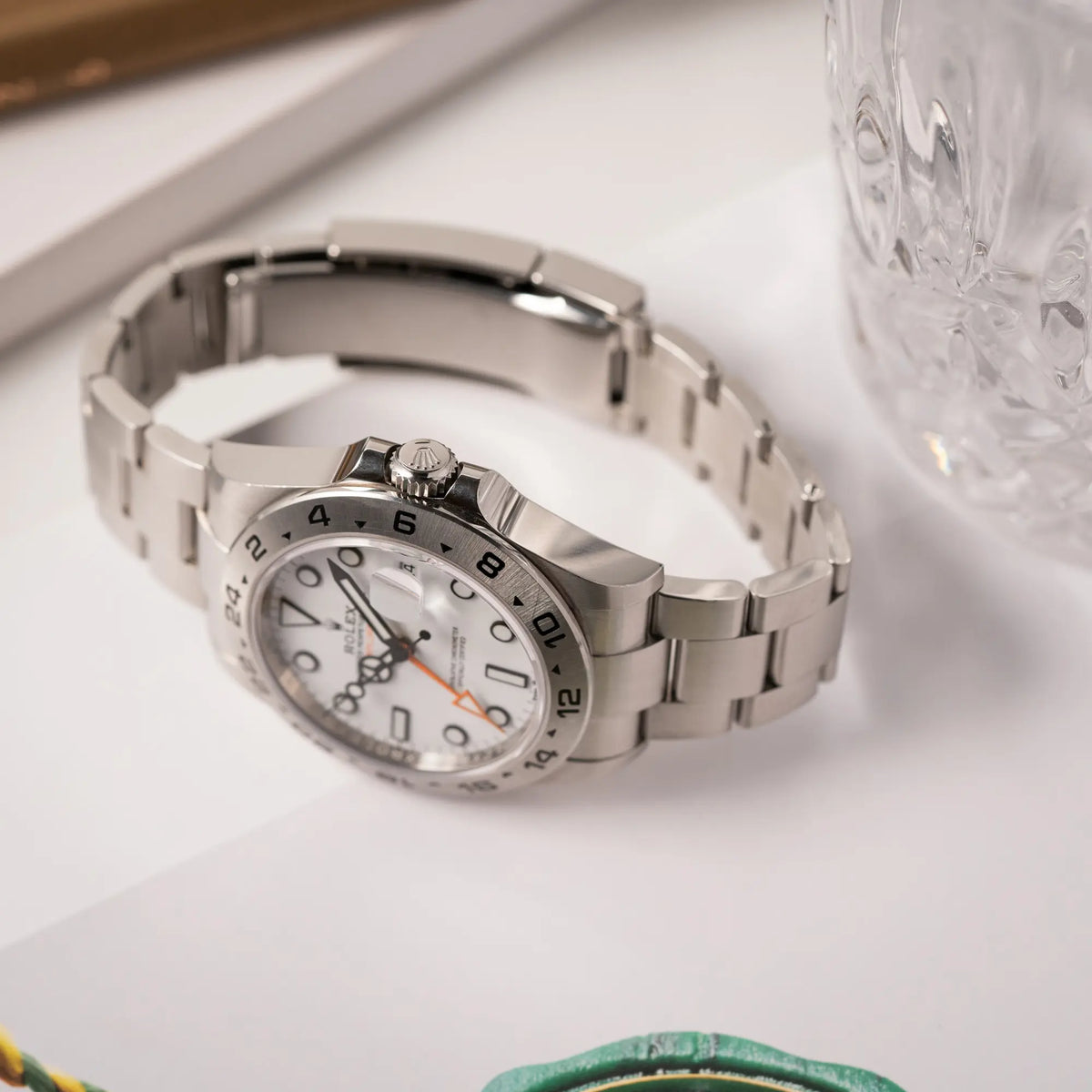Produktfotografie der Rolex Explorer II der Referenz 226570 am Oyster-Stahlband mit dem weißen Polar-Zifferblatt und dem typischen orangen 24-Stunden-Zeiger zeigt die Aufzugskrone