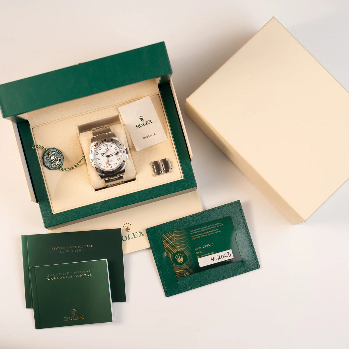 Rolex Explorer 2 der Referenz 226570 mit dem Polar Zifferblatt und orangem GMT-Zeiger zusammen mit dem Lieferumfang, besthend aus Box, Papieren (Garantiekarte), Hnagtag, Booklets und Umkarton
