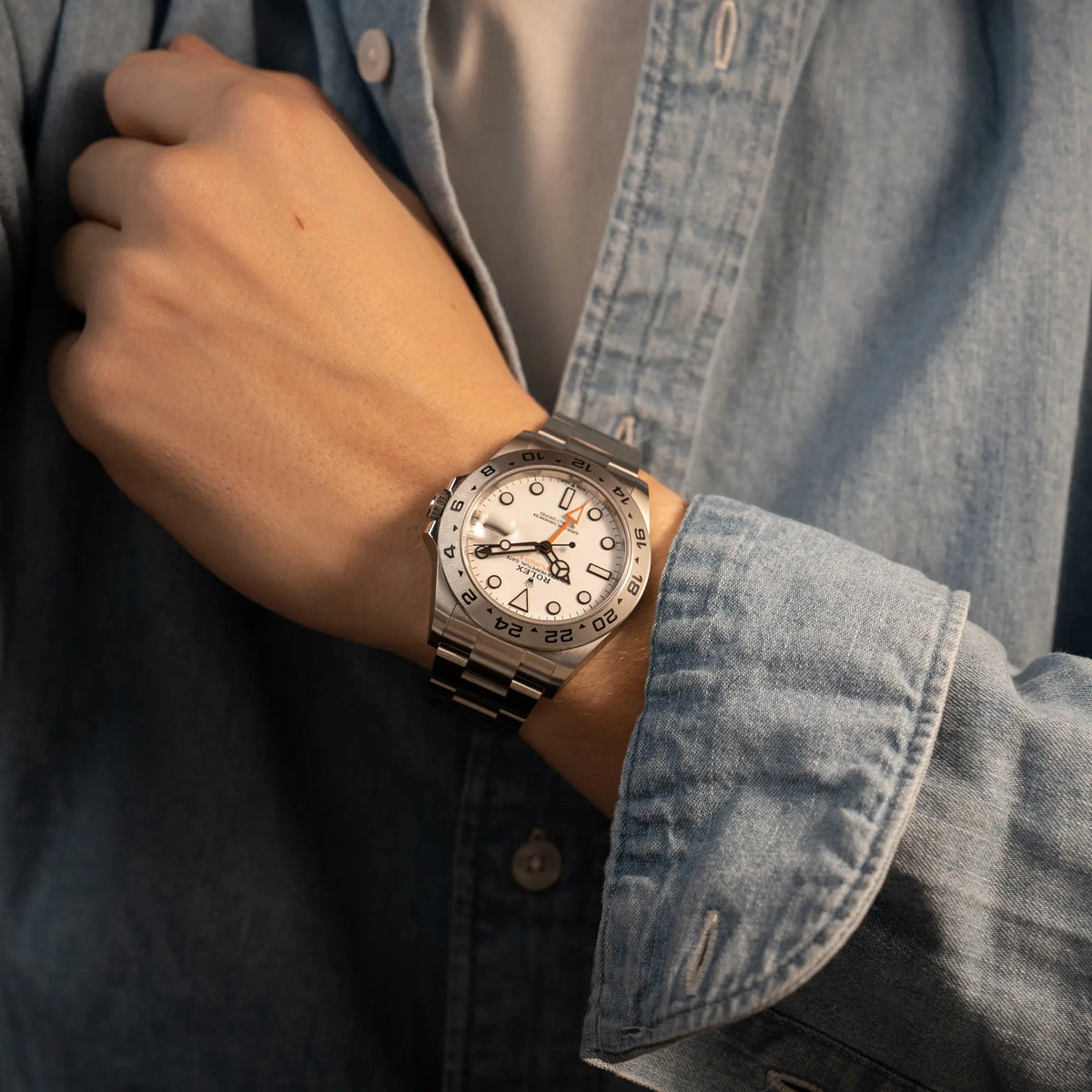 Mann trägt die Rolex Explorer 2 der Referenz 226570 mit dem Polar Zifferblatt und orangem GMT-Zeiger am Handgelenk