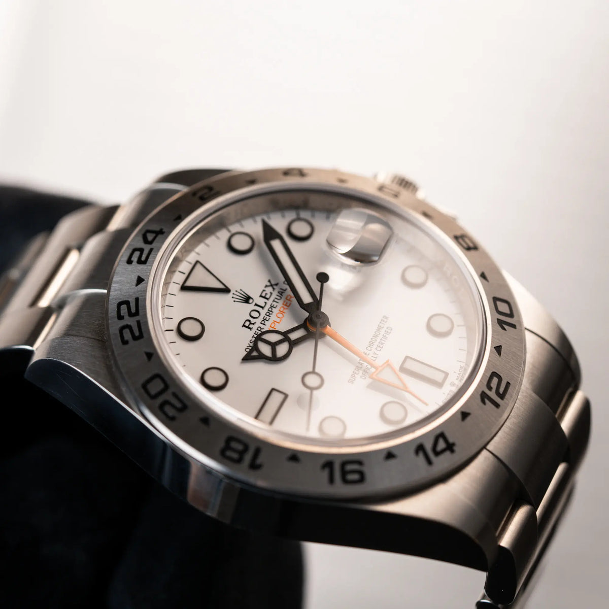 Detailaufnahme des Uhrenkopfes der Rolex Explorer 2 der Referenz 226570 mit dem Polar Zifferblatt und orangem GMT-Zeiger (seitliche Ansicht)