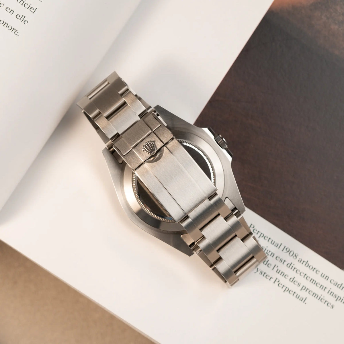 Produktfotografie der Rolex Explorer 2 der Referenz 226570 mit dem Polar Zifferblatt und orangem GMT-Zeiger zeigt den Gehäuseboden und die Oyster-Faltschliesse