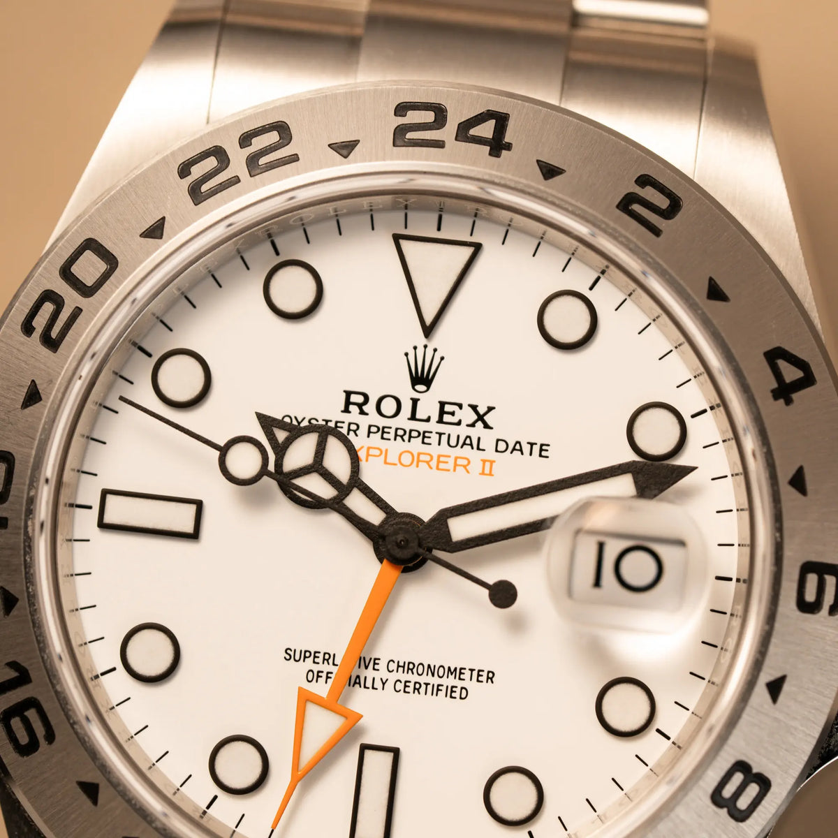 Makroaufnahme der Rolex Explorer 2 der Referenz 226570 mit dem Polar Zifferblatt und orangem GMT-Zeiger zeigt den Zustand des "Polar"-Dials und der Lünette aus Edelstahl