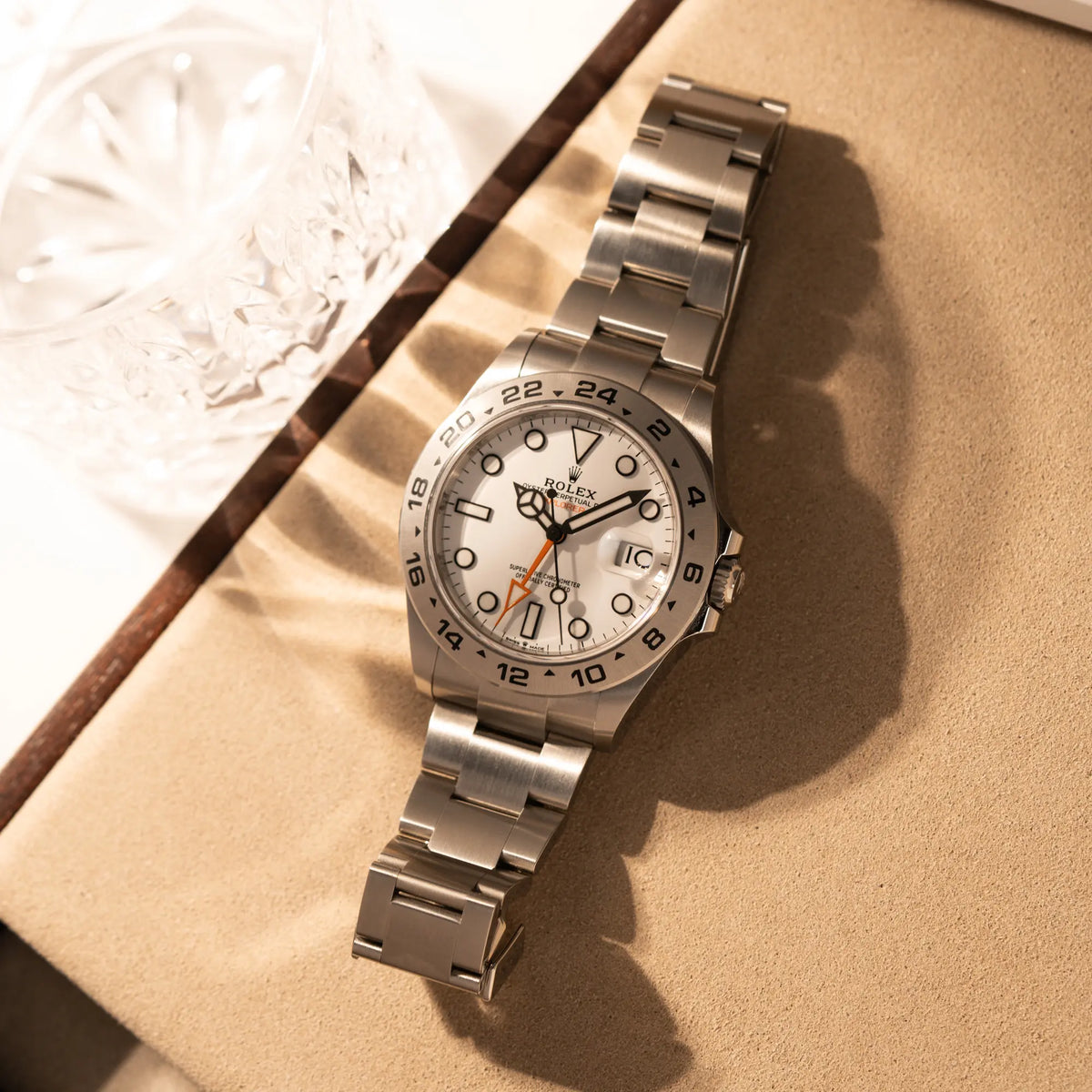 Produktfotografie der Rolex Explorer 2 der Referenz 226570 mit dem Polar Zifferblatt und orangem GMT-Zeiger auf einem Juwelierstablet