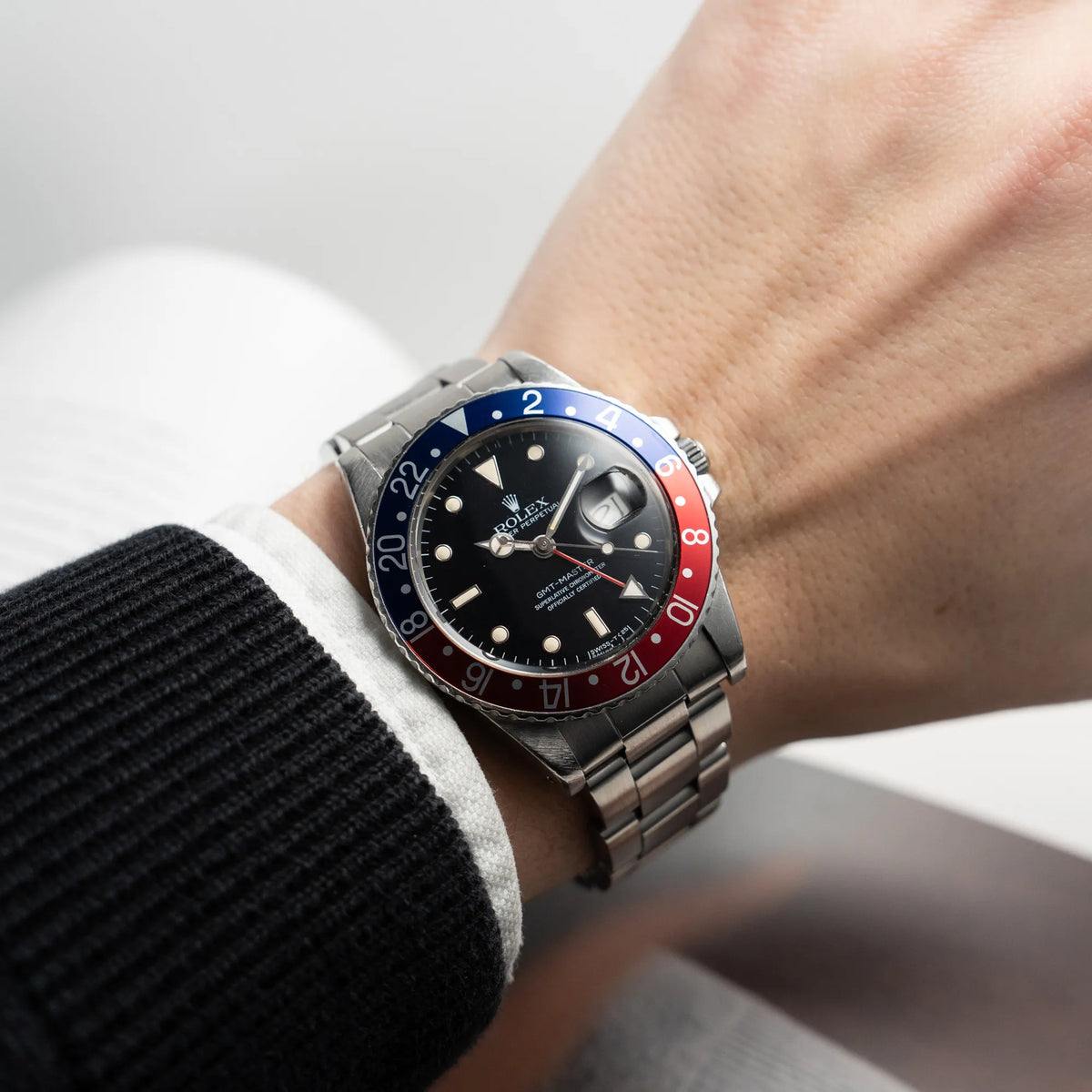 Mann präsentiert der Kamera die Rolex GMT Master 1675 mit dem Nickname Pepsi mit blau-roter Lynette an seinem Handgelenk 