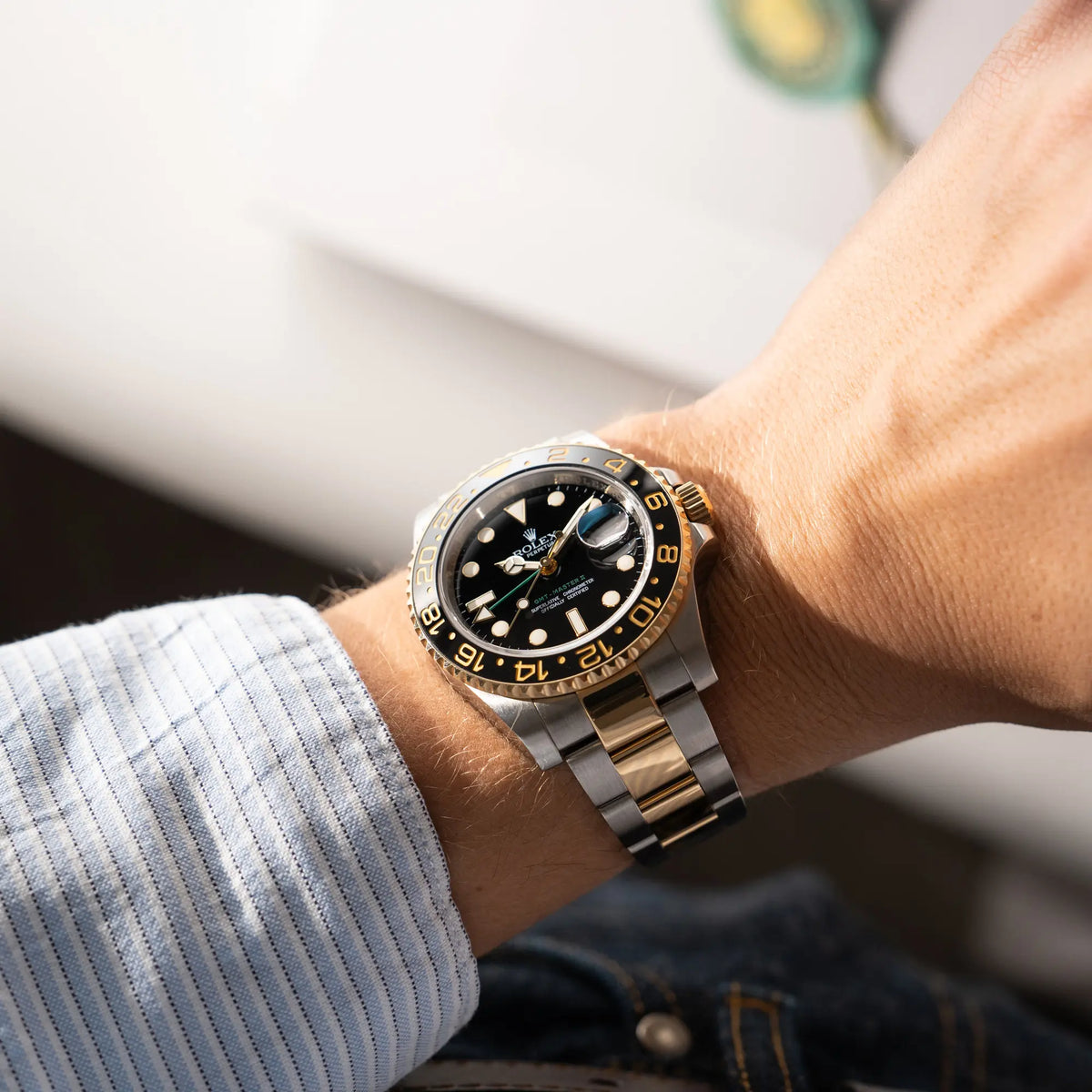 Wristhshot mit der Rolex GMT-Master II der Referenz 116713LN in Stahl-Gold mit schwarzem Zifferblatt und dem grünen GMT-Zeiger an einem Männerhgandgelenk