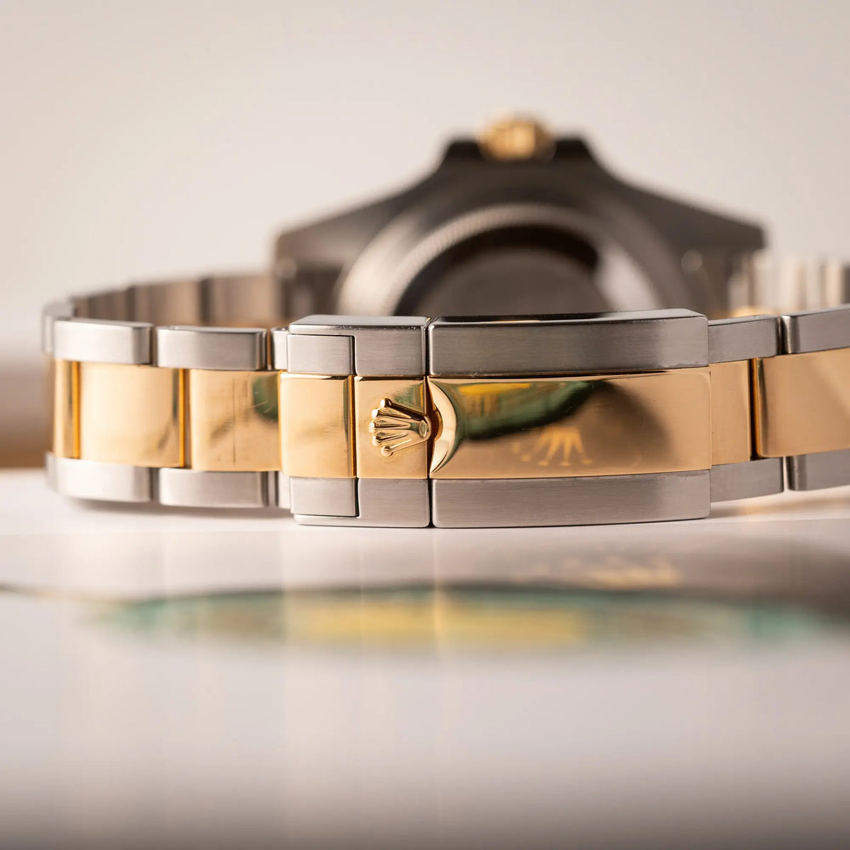 Detailaufnahme der Oyster-Schliesse von der Rolex GMT-Master II der Referenz 116713LN in Stahl-Gold mit schwarzem Zifferblatt und dem grünen GMT-Zeiger 