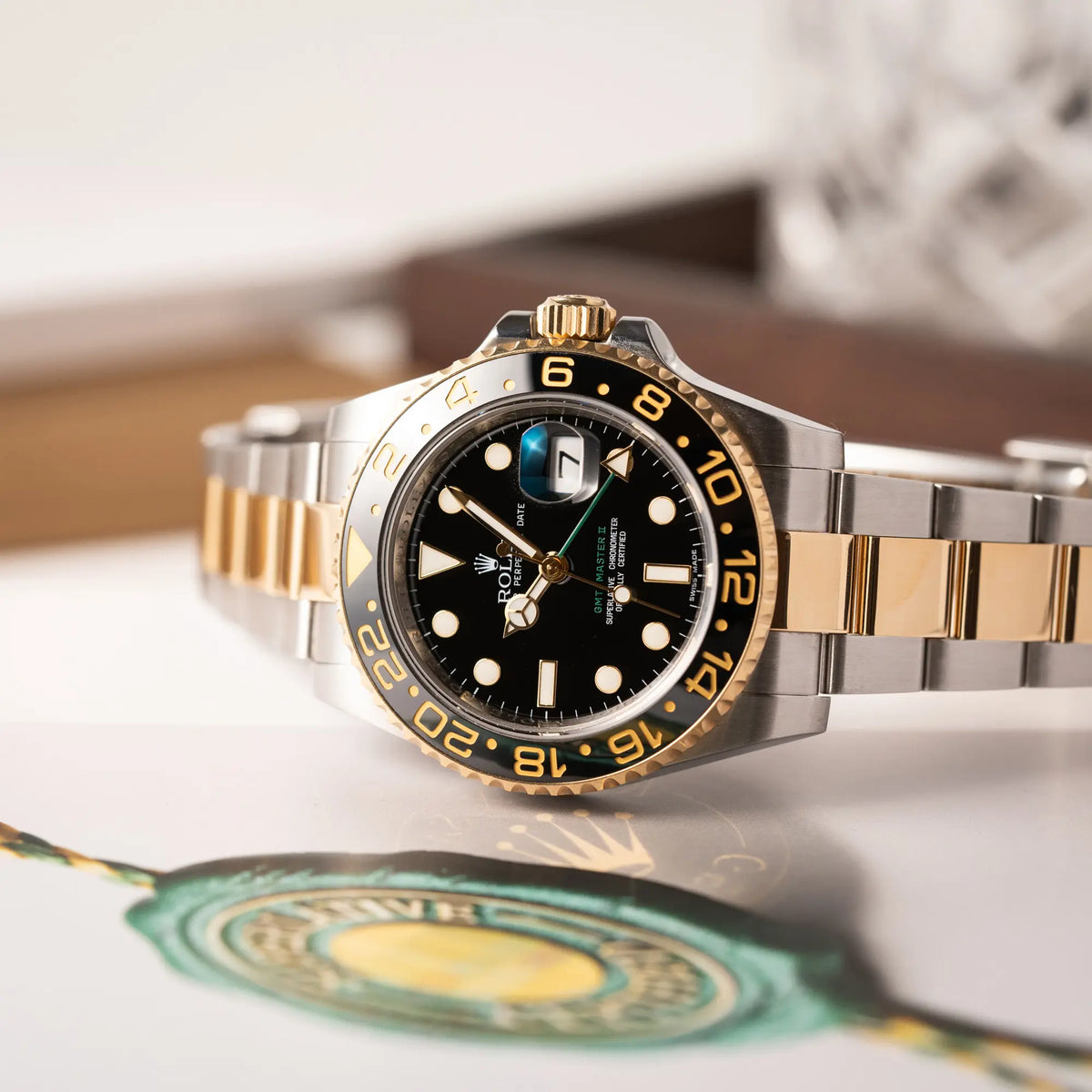 Produktfotografie als Titelbild der Rolex GMT-Master II der Referenz 116713LN in Stahl-Gold mit schwarzem Zifferblatt und dem grünen GMT-Zeiger