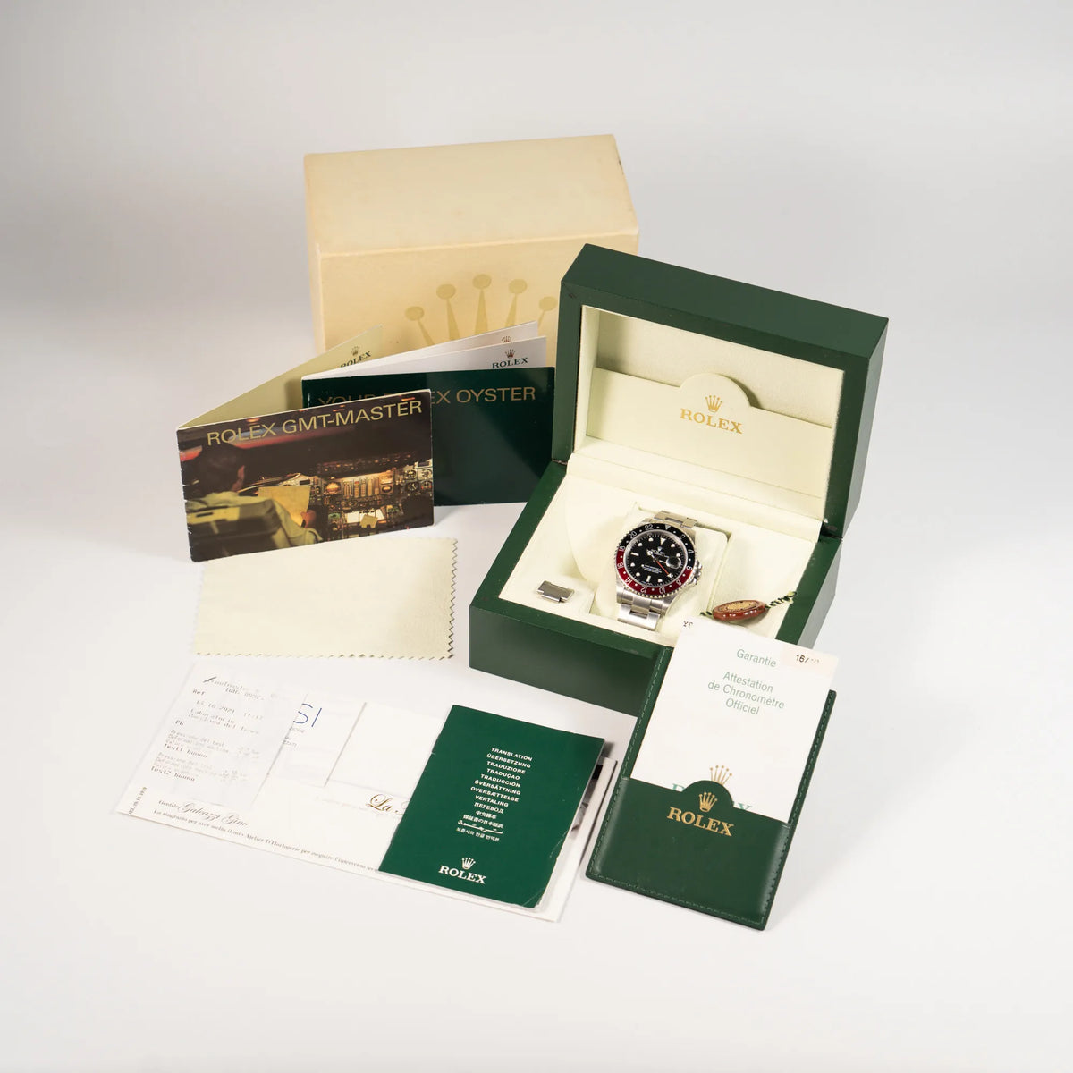 Lieferumfang der Rolex GMT-Master II 16710 mit der schwarz-roten "Coke" Aluminium-Lünetten-Einlage aus 2003 am Oyster Stahlband, bestehend aus Box mit Umkarton, Papieren, Booklets und Service-Belegen