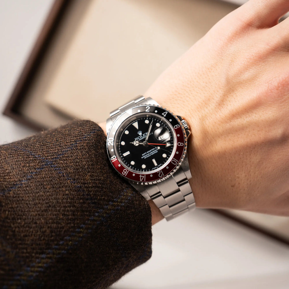 Mann trägt die Rolex GMT-Master II 16710 mit der schwarz-roten "Coke" Aluminium-Lünetten-Einlage aus 2003 am Oyster Stahlband für einen Wristshot