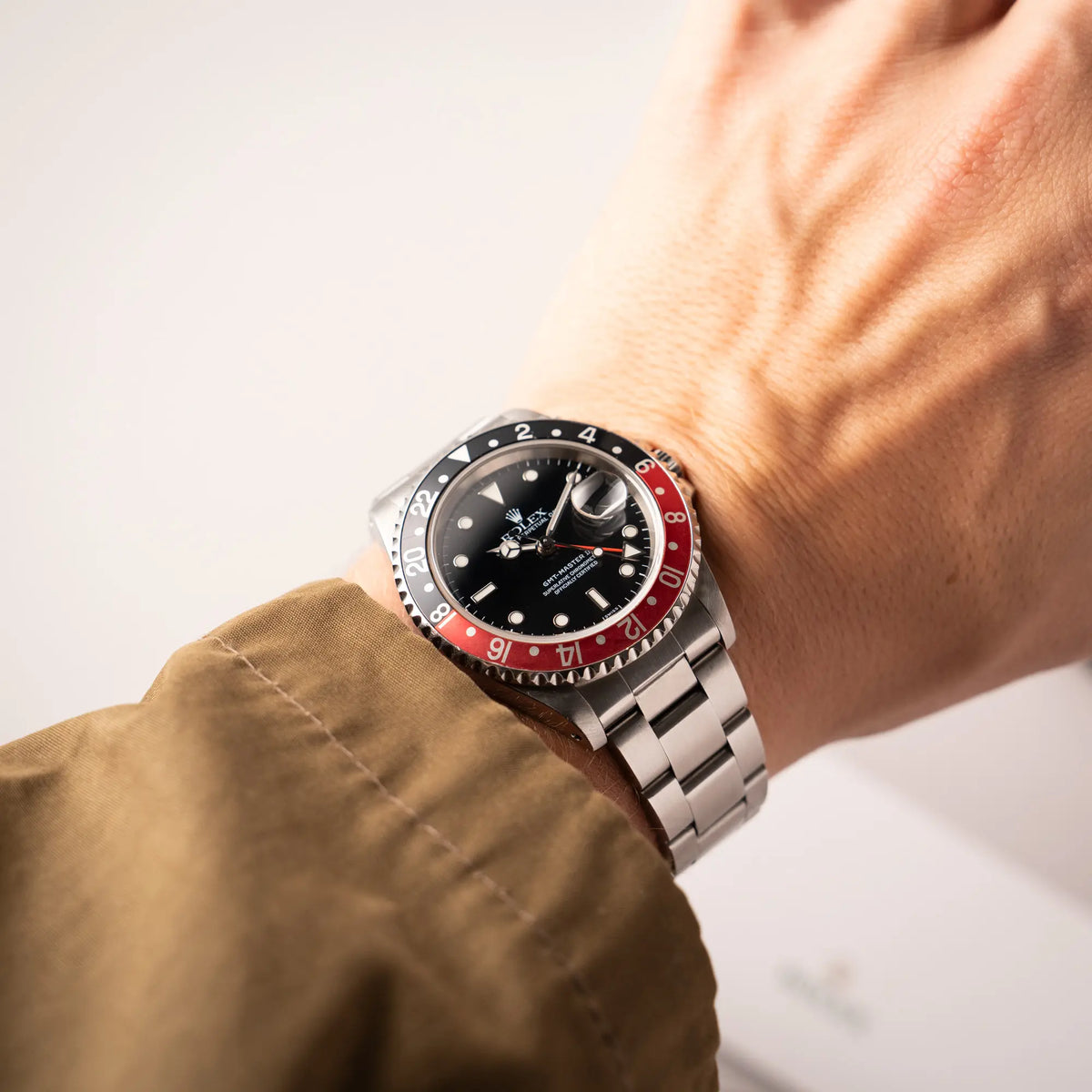 Mann trägt die Rolex GMT-Master II der Referenz 16710  2000 mit  schwarz-roter Coke-Lünette und dem für das Jahr 2000 typische "Swiss Only" - Zifferblatt an seinem Handgelenk