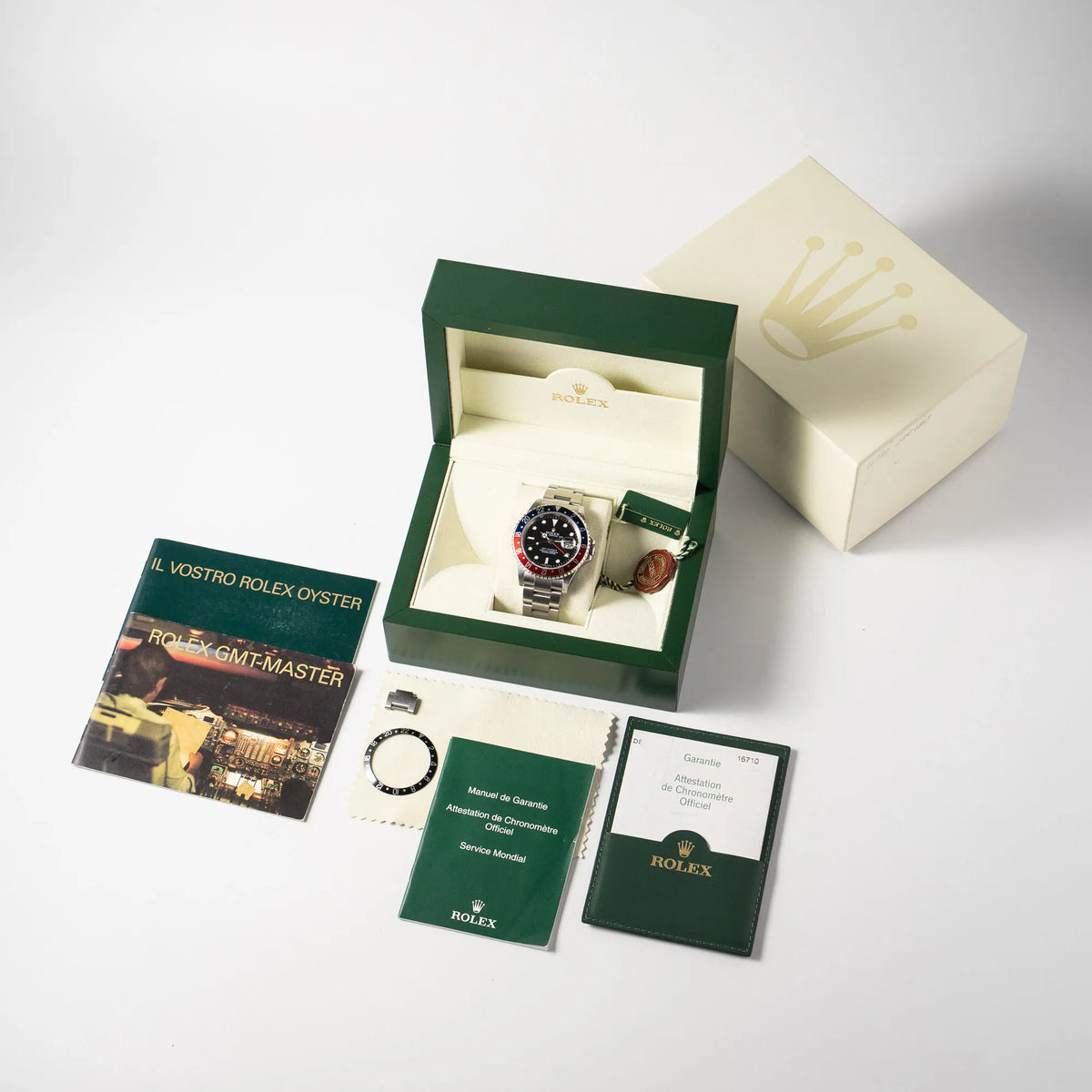 Lieferumfang zu der Rolex GMT-Master II der Referenz 16710 mit der blau-roten Pepsi Lünette aus Aluminium mit kräftigen Farben, bestehend aus Box mit Umkarton, Hangtag, Booklets, originaler Garantiekarte und zusätzlicher schwarzer Lünetten-Einlage