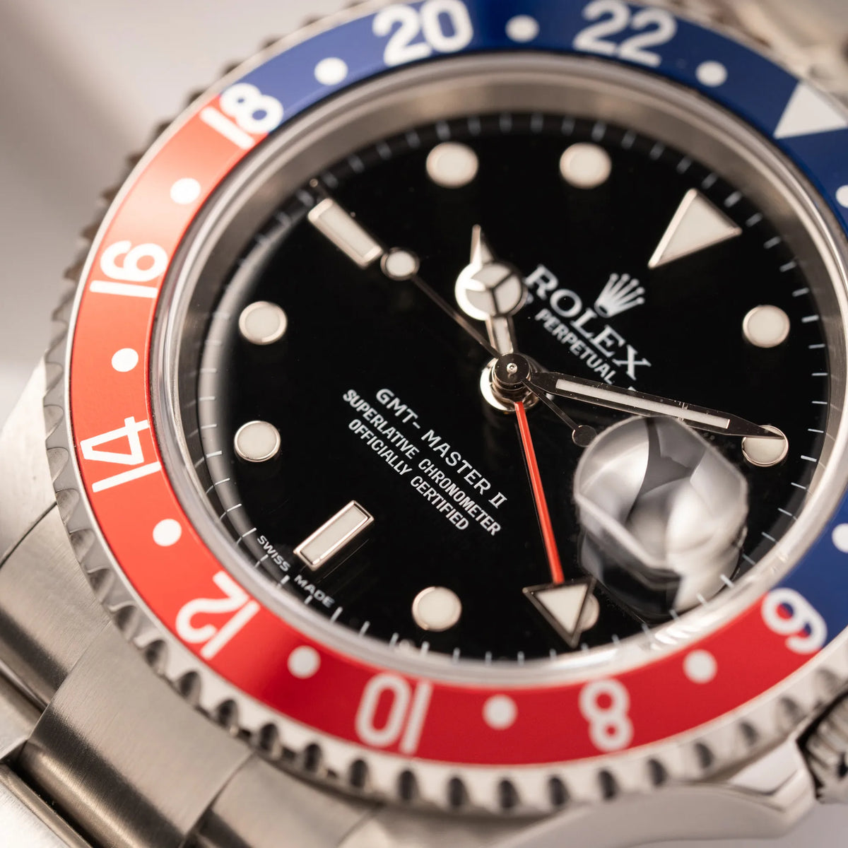 Nahaufnahme der Rolex GMT-Master II der Referenz 16710 mit der blau-roten Pepsi Lünette aus Aluminium mit kräftigen Farben mit Fokus auf dem GMT-Master 2 - Schriftzug