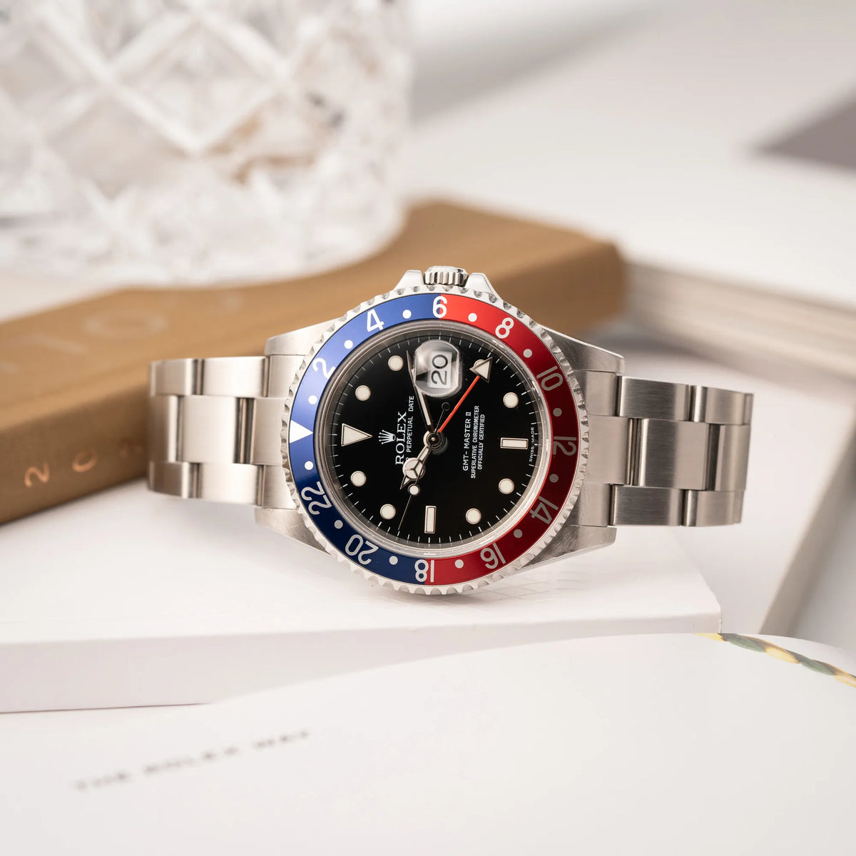 Rolex GMT-Master II der Referenz 16710 mit der blau-roten Pepsi Lünette aus Aluminium mit kräftigen Farben liegt seitlich auf der Gehäuseflanke der Uhr