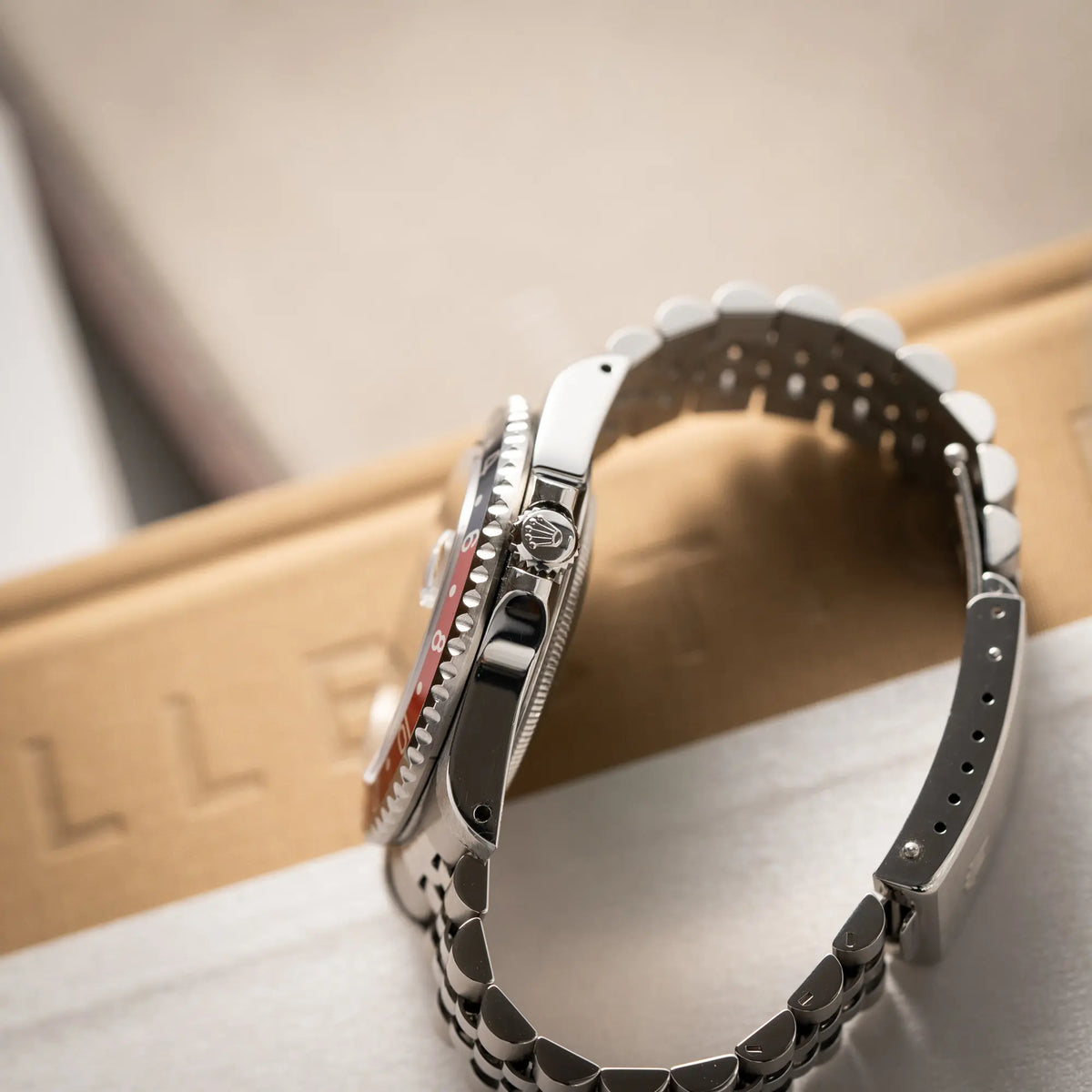 Produktfotografie der Rolex GMT-Master II 16710 mit der blau-roten Pepsi-Lünette am Jubilee-Armband  zeigt die seitliche Gehäuseflanke mit Blick auf die Aufzugskrone