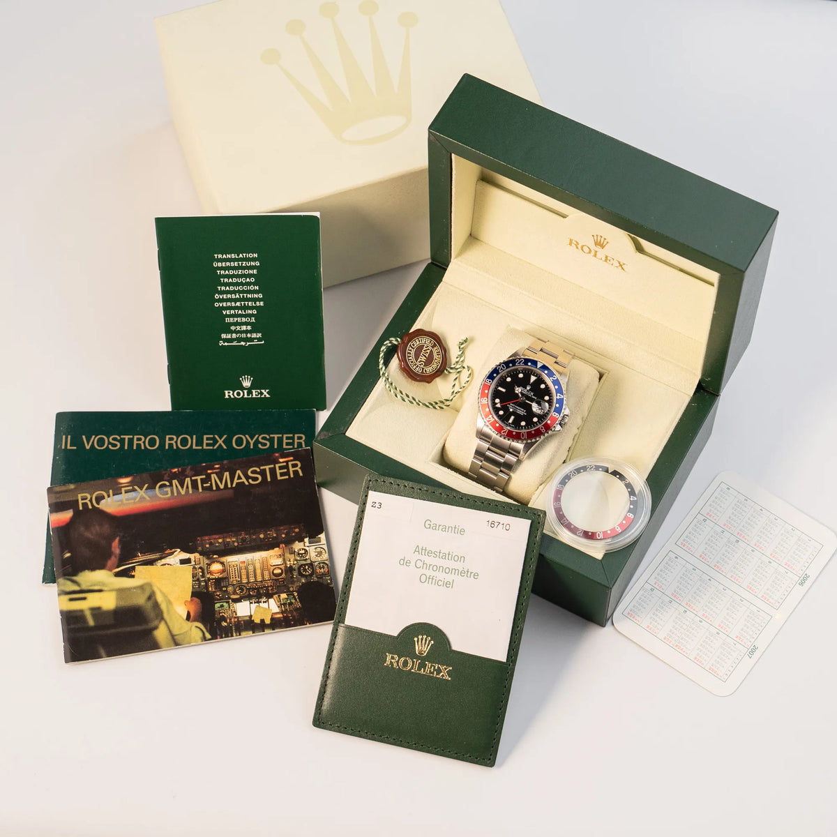 Rolex GMT-Master II 16710 aus 2007 mit blau-roter Pepsi-Lünette mit kräftigen Farbtönen zusammen mit dem Lieferumfang bestehend aus Box, papieren, Booklets, Kalender, Hangtag, und zusätzlicher Coke-Lünette