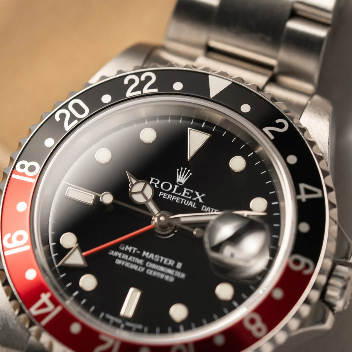 Makro-Aufnahme der Rolex GMT-Master II der Referenz 16710 mit der schwarz-roten "Coke"-Lünette aus 2007 mit dem "No-Hole"-Uhrengehäuse