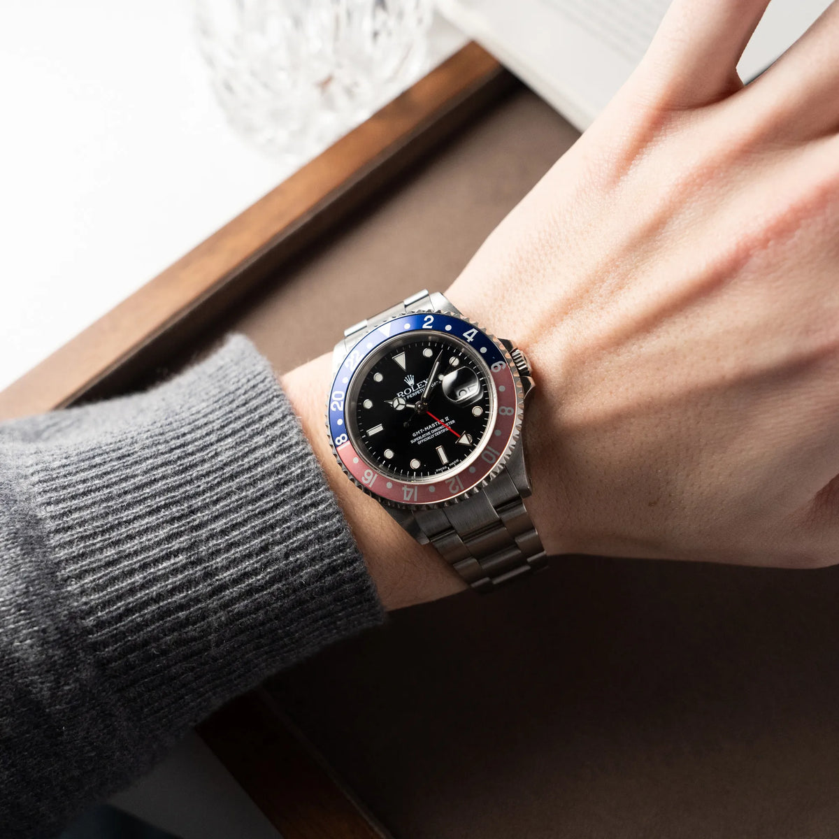 Mann trägt die Rolex GMT-Master 2 der Referenz 16710 mit der blau-roten Pepsi Lünette, die einen wunderschönen verblichenen Raspberry-Farbton