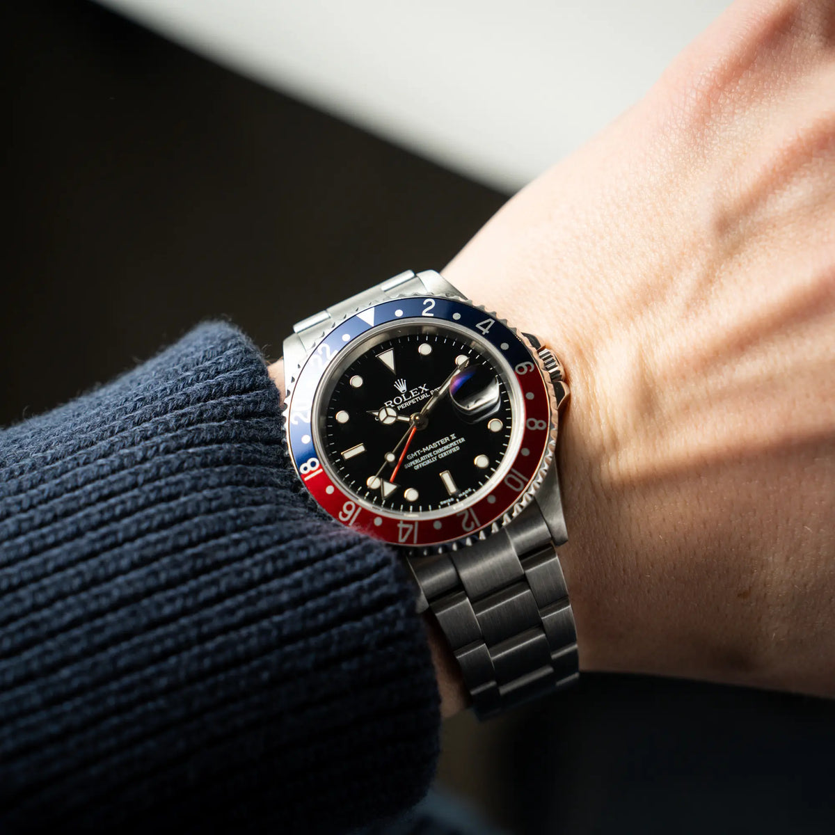 Mann trägt die Rolex GMT-Master II Pepsi der Referenz 16710 mit der blau-roten Aluminium-Lünette an seinem Männerhandgelenk für einen Wristshot