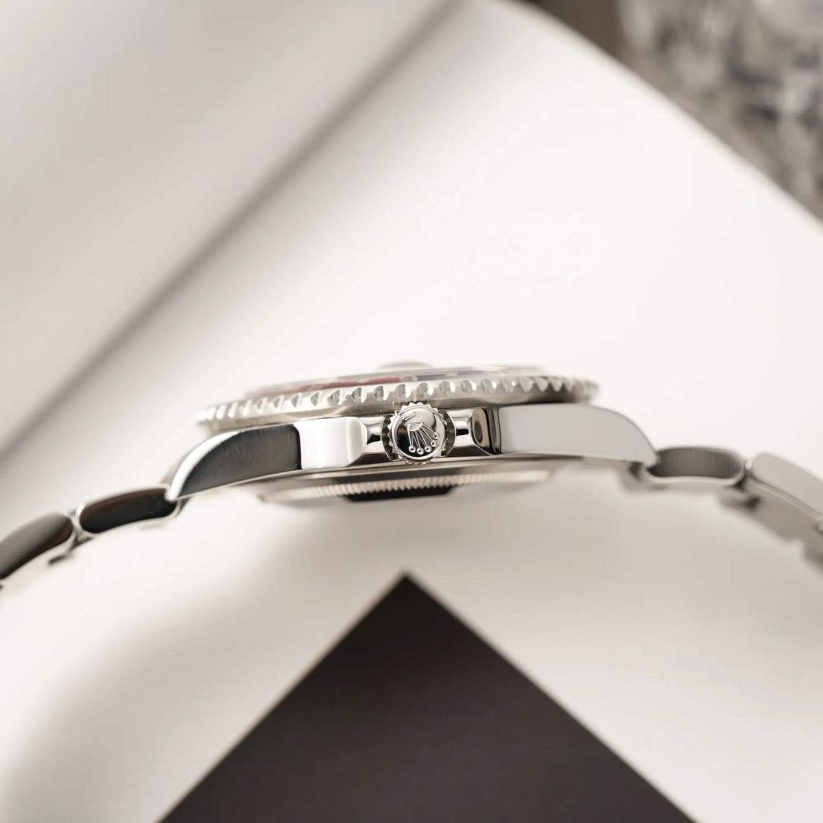 Produktfotografie der Rolex GMT-Master II Pepsi der Referenz 16710 mit der blau-roten Aluminium-Lünette zeigt die seitliche Gehäuseflanke und die Aufzugskrone