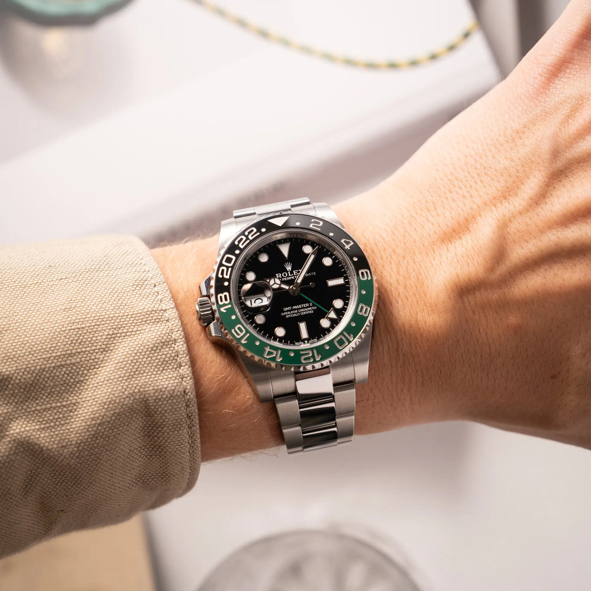 Wristshot mit der Rolex GMT-Master II der Referenz 126720VTNR mit dem Nickname "Sprite" mit einer schwarz-grünen Keramik-Lünette am Oyster-Stahlband im neuwertigen Zustand, mit der Besonderheit der links liegenden Aufzugskrone, so dass Linkshänder die Uhr an der rechten Hand tragen können