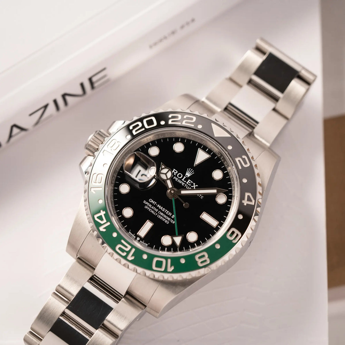 Produktfotografie als Titelbild Rolex GMT-Master II der Referenz 126720VTNR mit dem Nickname "Sprite" mit einer schwarz-grünen Keramik-Lünette am Oyster-Stahlband im neuwertigen Zustand, mit der Besonderheit der links liegenden Aufzugskrone, so dass Linkshänder die Uhr an der rechten Hand tragen können
