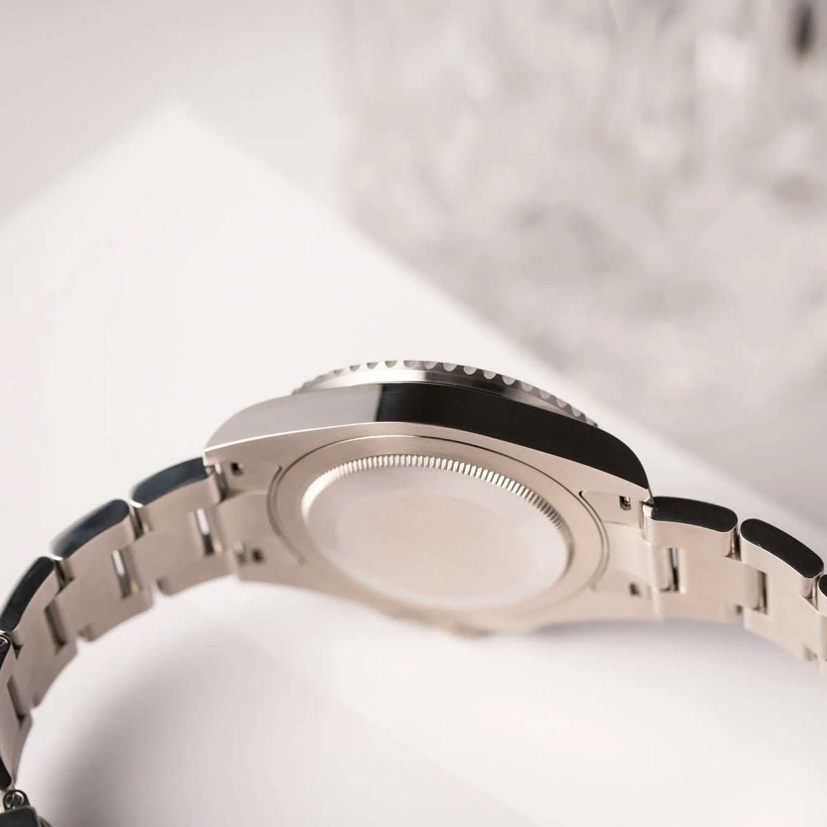 Seitliche Gehäuseflanke der Rolex GMT-Master II der Referenz 126720VTNR mit dem Nickname "Sprite" mit einer schwarz-grünen Keramik-Lünette am Oyster-Stahlband im neuwertigen Zustand, mit der Besonderheit der links liegenden Aufzugskrone, so dass Linkshänder die Uhr an der rechten Hand tragen können