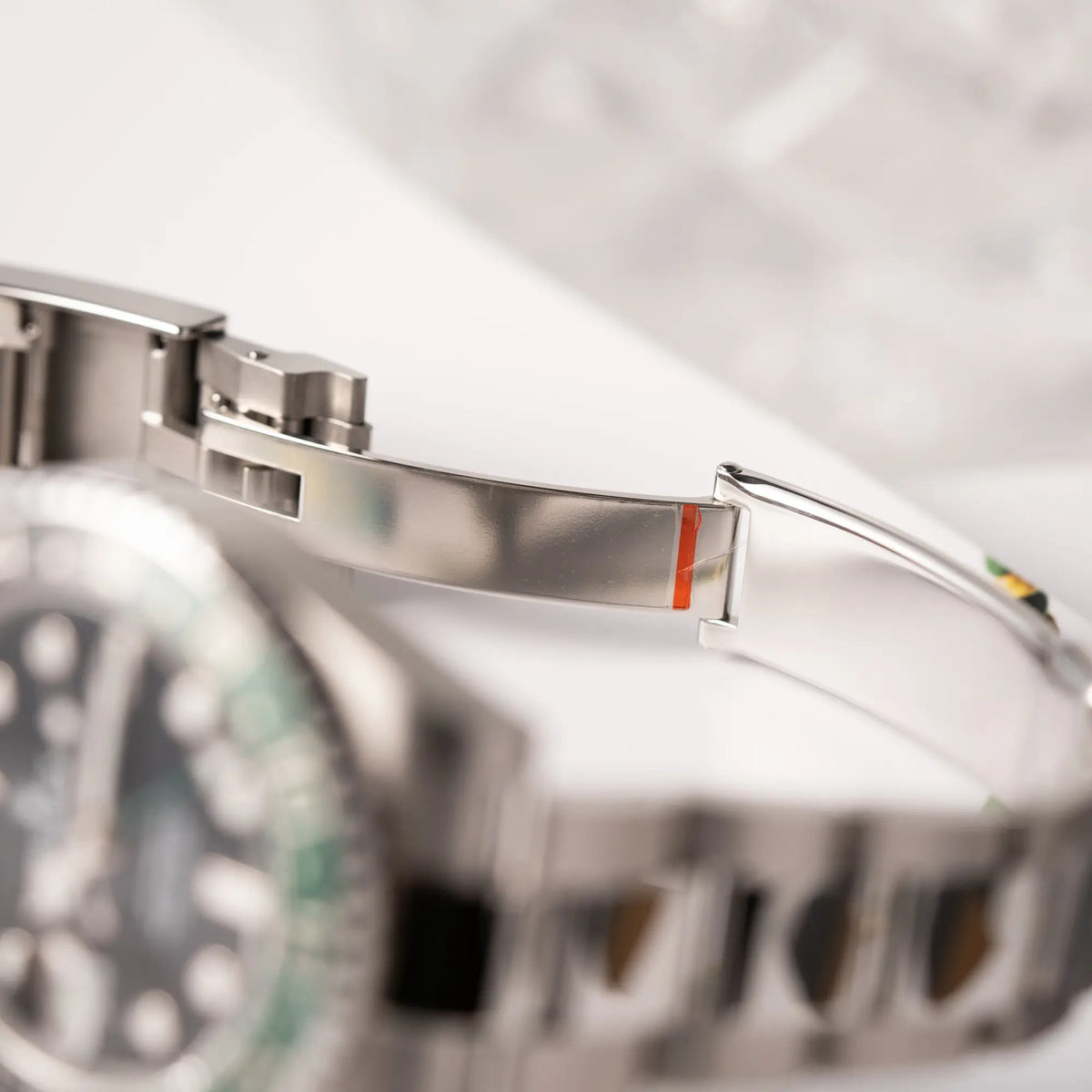Verklebte Faltschliesse der Rolex GMT-Master II der Referenz 126720VTNR mit dem Nickname "Sprite" mit einer schwarz-grünen Keramik-Lünette am Oyster-Stahlband im neuwertigen Zustand, mit der Besonderheit der links liegenden Aufzugskrone, so dass Linkshänder die Uhr an der rechten Hand tragen können
