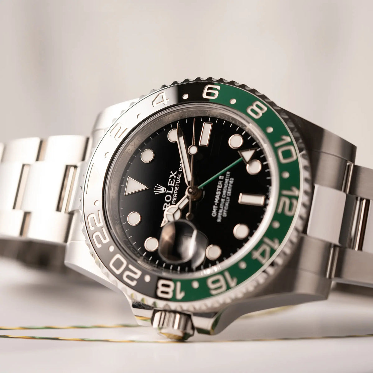 Detailaufnahme der Rolex GMT-Master II der Referenz 126720VTNR mit dem Nickname "Sprite" mit einer schwarz-grünen Keramik-Lünette am Oyster-Stahlband im neuwertigen Zustand, mit der Besonderheit der links liegenden Aufzugskrone, so dass Linkshänder die Uhr an der rechten Hand tragen können