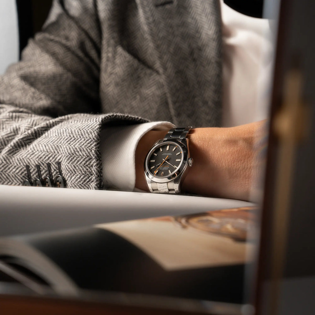Mann trägt die Rolex Milgauss der Referenz  116400 mit schwarzem Zifferblatt und orangen Akzenten an seine Handgelenk