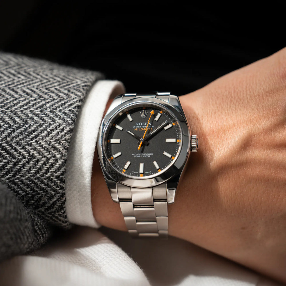 Mann trägt die Rolex Milgauss der Referenz  116400 mit schwarzem Zifferblatt und orangen Akzenten für einen Wristshot am Handgelenk