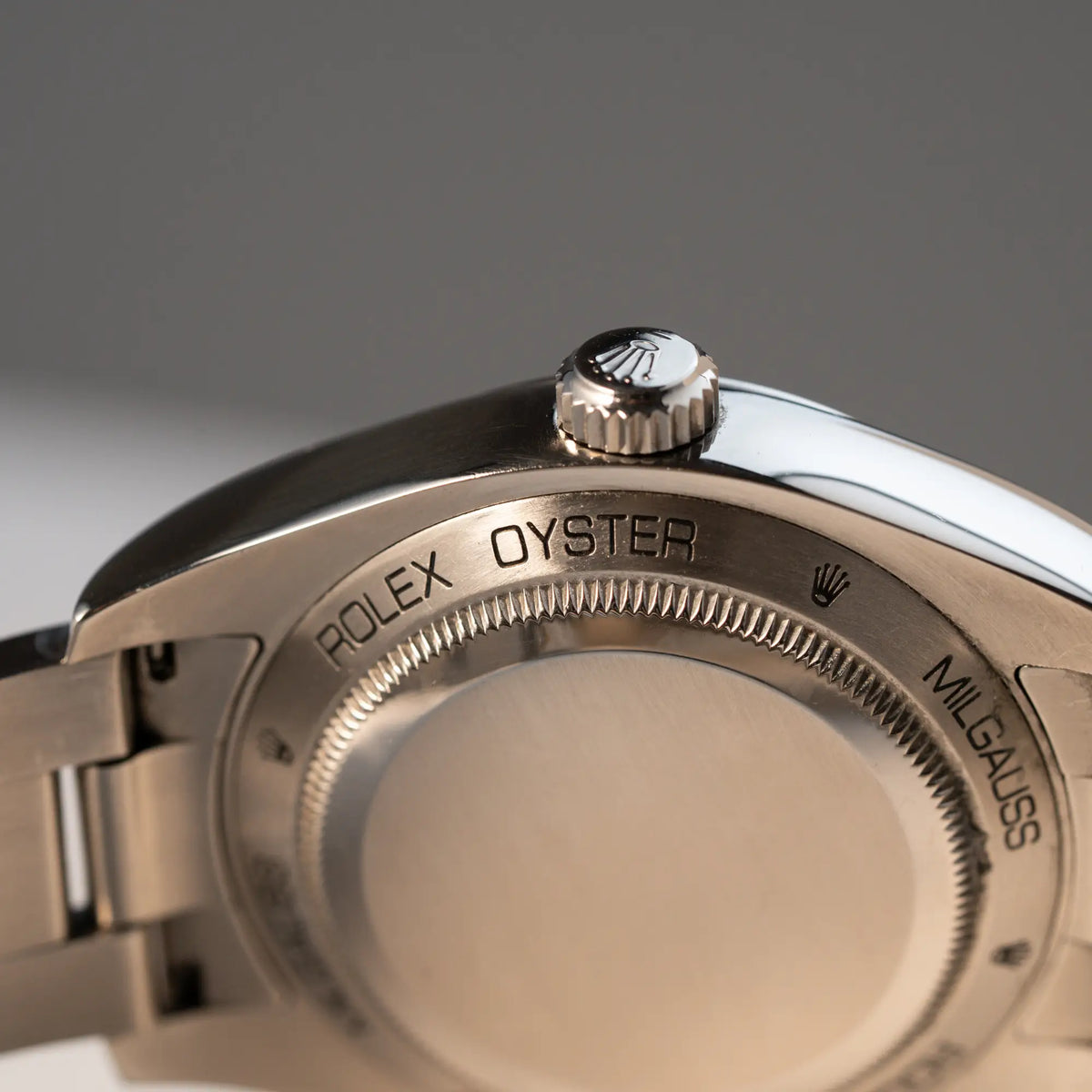Produktfoto der Rolex Milgauss der Referenz  116400 mit schwarzem Zifferblatt und orangen Akzenten mit Fokus auf dem Gehäuseboden und der Krone