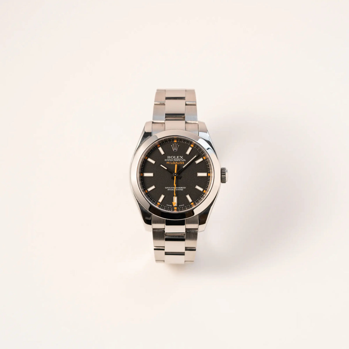 Frontale Ansicht der Rolex Milgauss der Referenz  116400 mit schwarzem Zifferblatt und orangen Akzenten