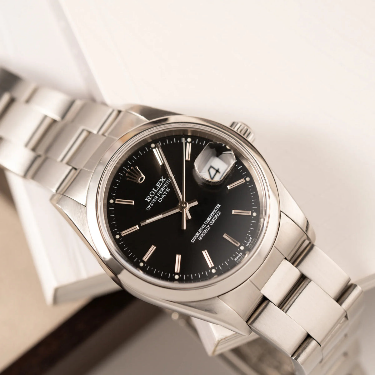 Detailaufnahme des Uhrenkopfes der Rolex Oyster Perpetual 34 mit schwarzem Zifferblatt der Referenz 15200 mit glatter Lünette und 34mm Gehäusedurchmesser