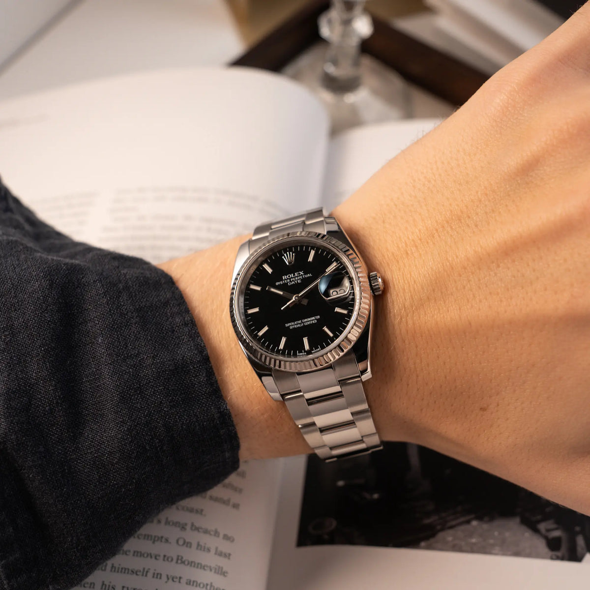 Wristshot mit der Rolex Oyster Perpetual Date 34 der Referenz 115234 mit schwarzem Zifferblatt und der geriffelten Weißgold-Lünette 