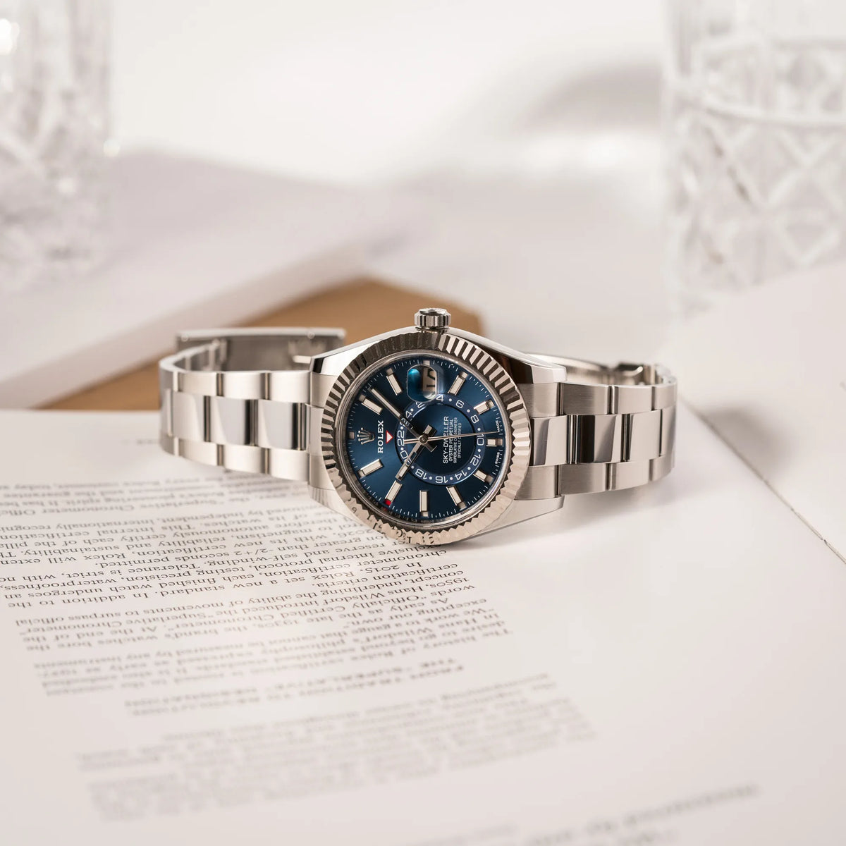 Jahreskalender Rolex Sky-Dweller der Referenz 326934 mit blauem Zifferblatt am Oyster-Stahlband liegt auf einem Uhrenbuch