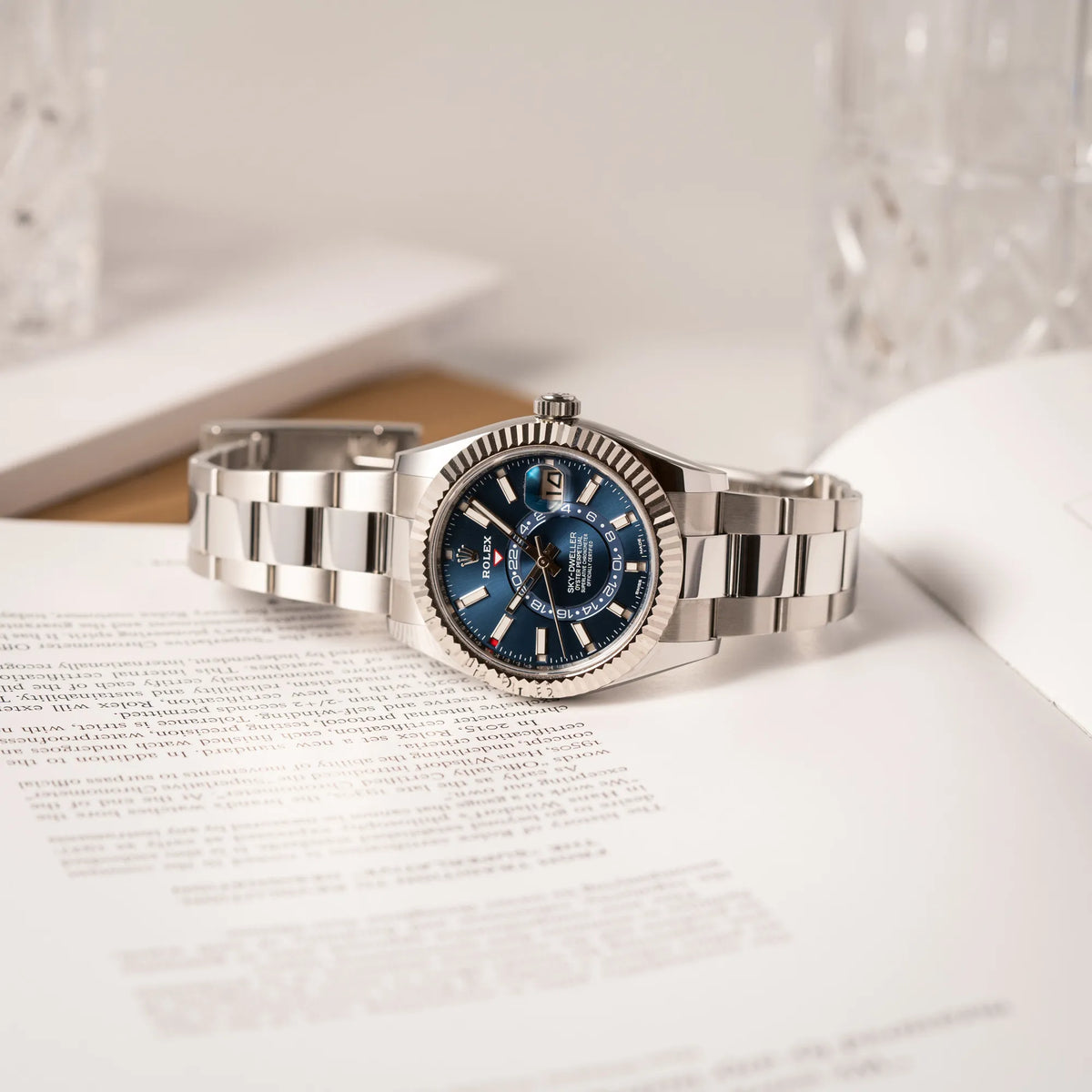 Jahreskalender Rolex Sky-Dweller der Referenz 326934 mit blauem Zifferblatt am Oyster-Stahlband liegt seitlich auf dem Uhrengehäuse