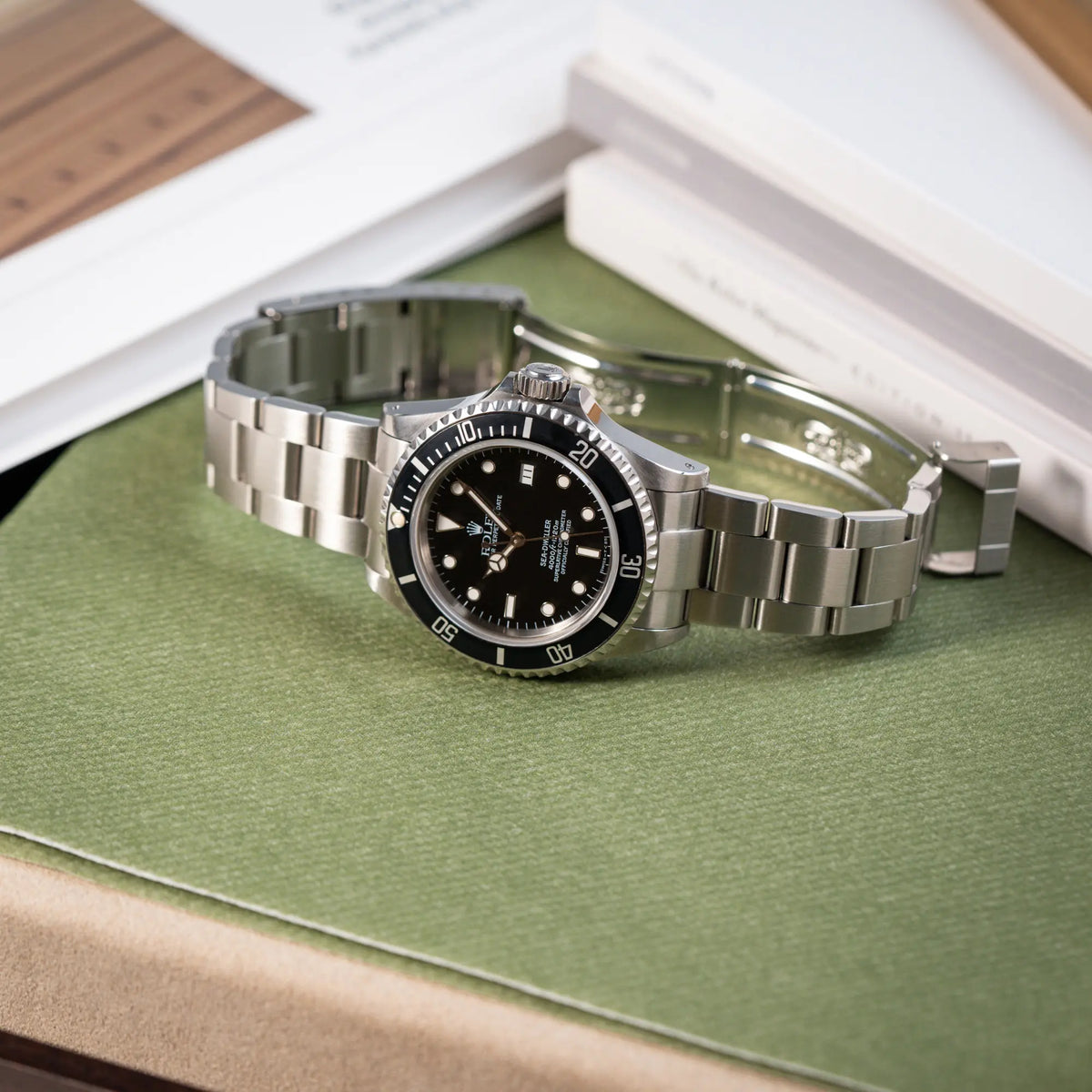 Produktfotografie der Rolex Sea-Dweller 4000 der Referenz 16600 mit 40mm-Oyster-Gehäuse und schwarzer Aluminium-Lünetten-Inlay mit geöffneter Faltschliesse