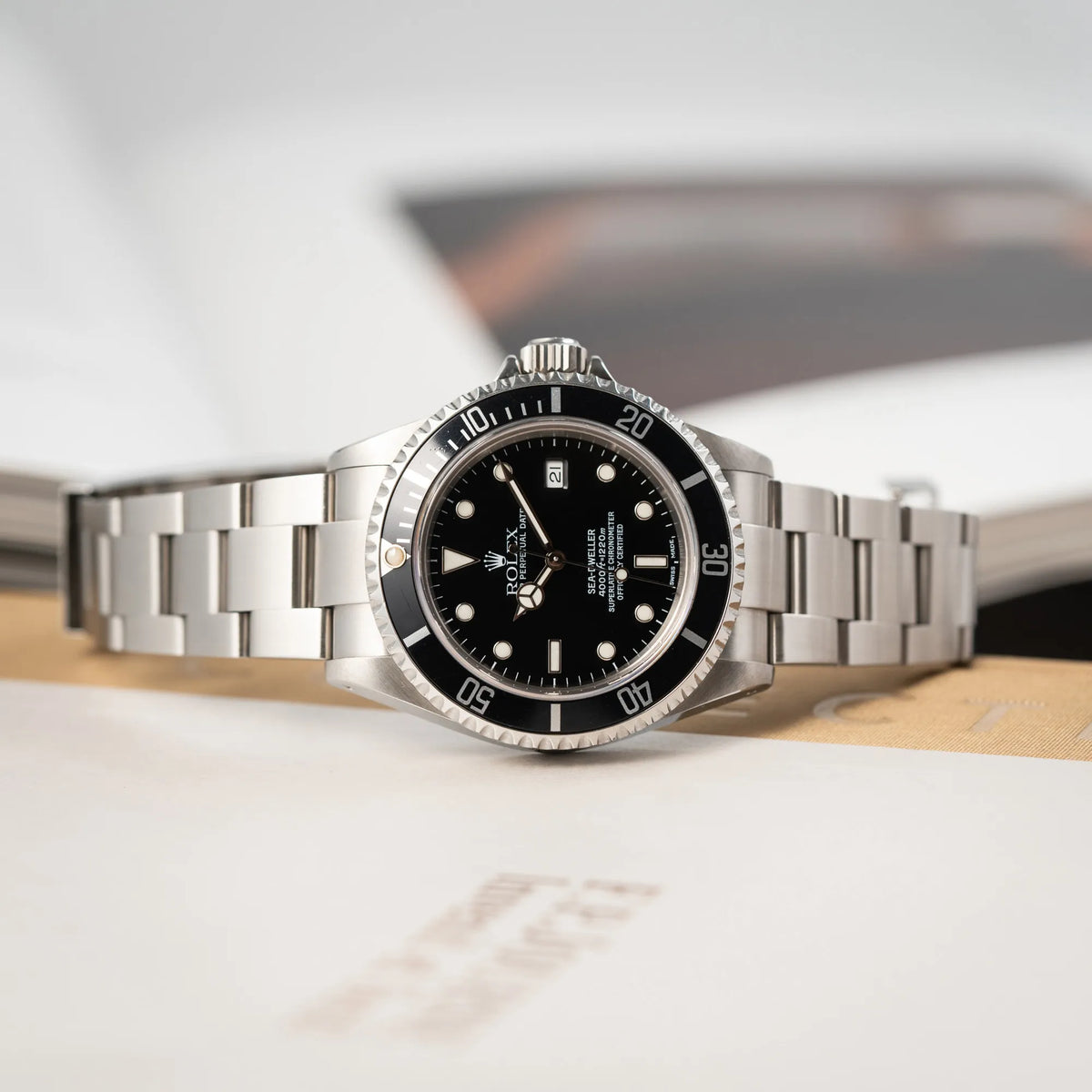Rolex Sea-Dweller 4000 der Referenz 16600 mit der klassischen schwarzen Aluminium-Lünette aus Dezember 2002 liegt auf der seitlichen Gehäuseflanke