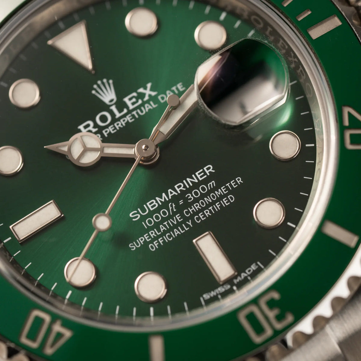 Makroaufnahme der Rolex Submariner Date 116610LV "Hulk" mit grünem Zifferblatt und grüner Keramik-Lünette mit Fokus auf dem Submariner-Schriftzug