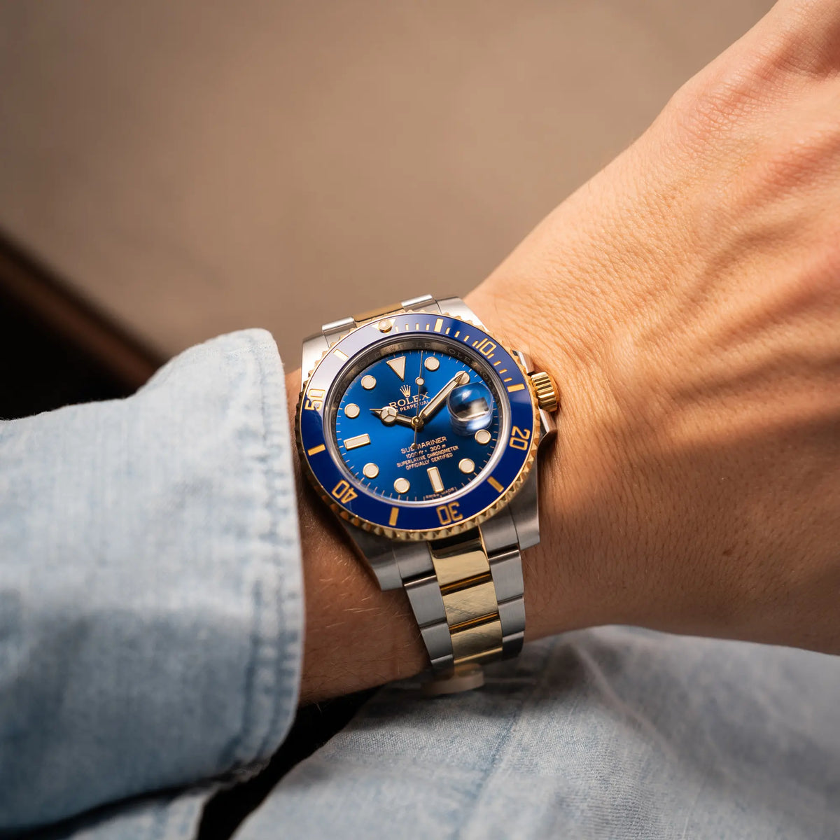 Mann trägt die Rolex Submariner Date der Referenz 116613LB in Stahl-Gold mit blauem Zifferblatt - auch mit Nickname Bluesy bennant - am passenden Oytser-Armband in Stahl-Gold an seinem Handgelenk