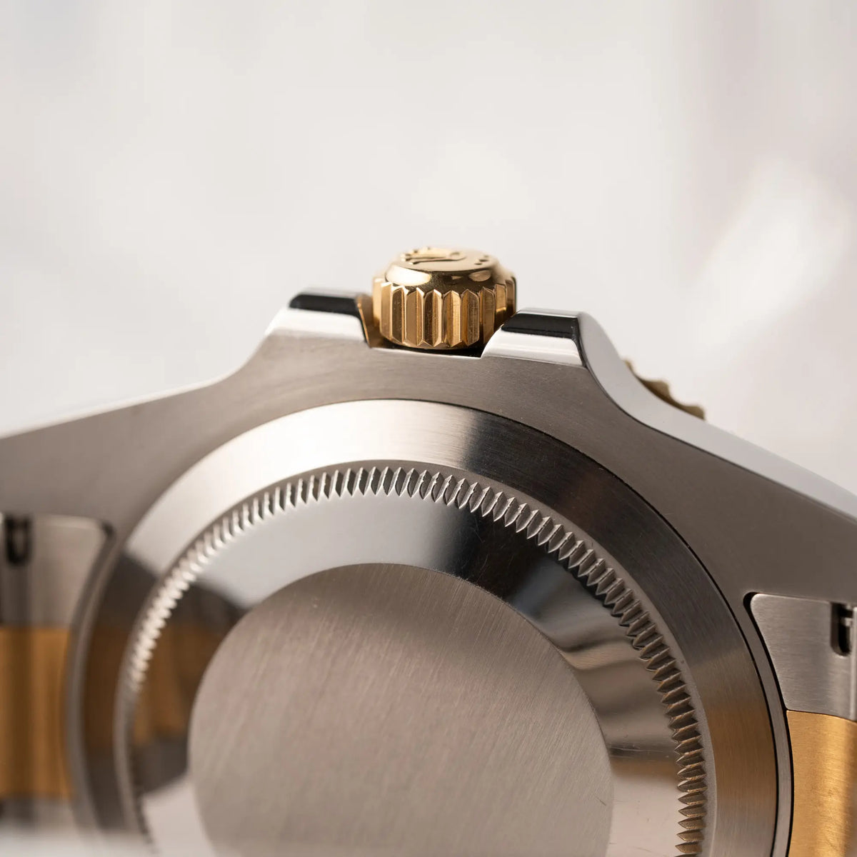 Detailaufnahme des Gehäusebodens und der goldenen Aufzugskrone von der Rolex Submariner Date der Referenz 116613LB in Stahl-Gold mit blauem Zifferblatt - auch mit Nickname Bluesy bennant - am passenden Oytser-Armband in Stahl-Gold